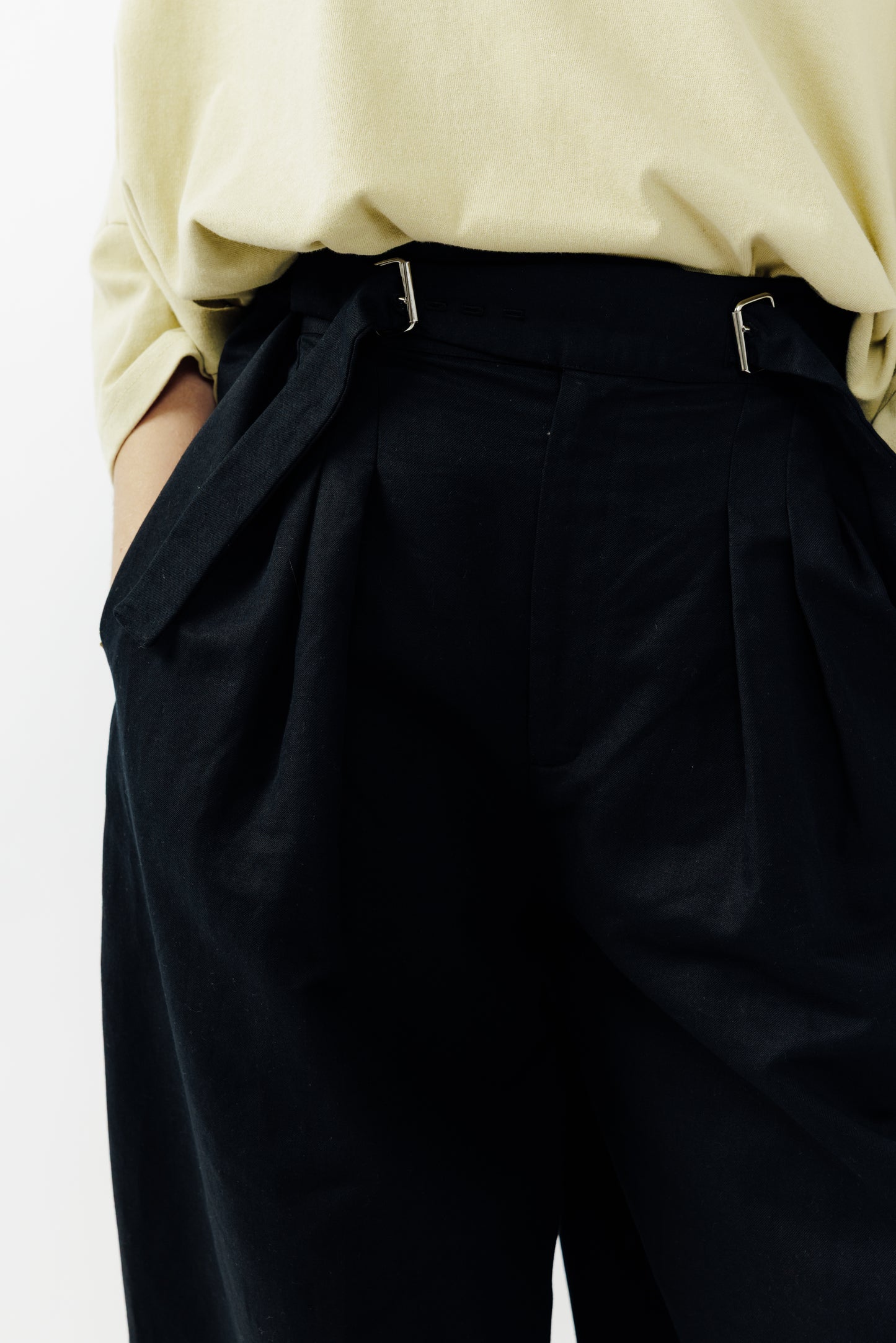 Pantalon circulaire de la marque Aïdama, coupe ballon en coton et lin noir avec ceinture ajustable. Porté par une mannequin femme et vu zoomé sur la ceinture.