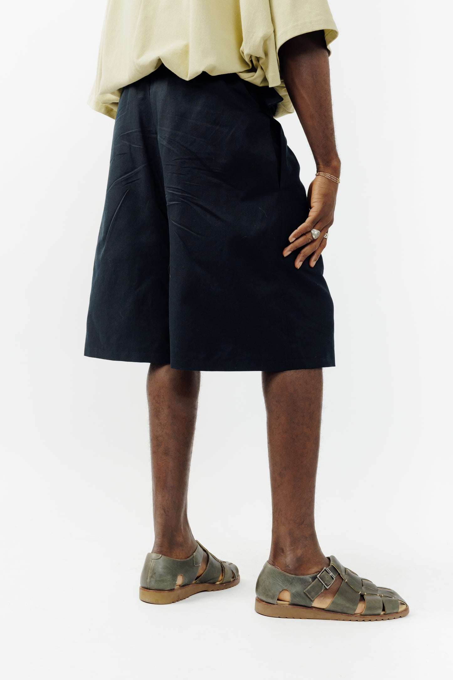 Short ballon de la marque Aïdama en coton & lin noir avec ceinture ajustable. Porté par un mannequin homme et vu de dos.