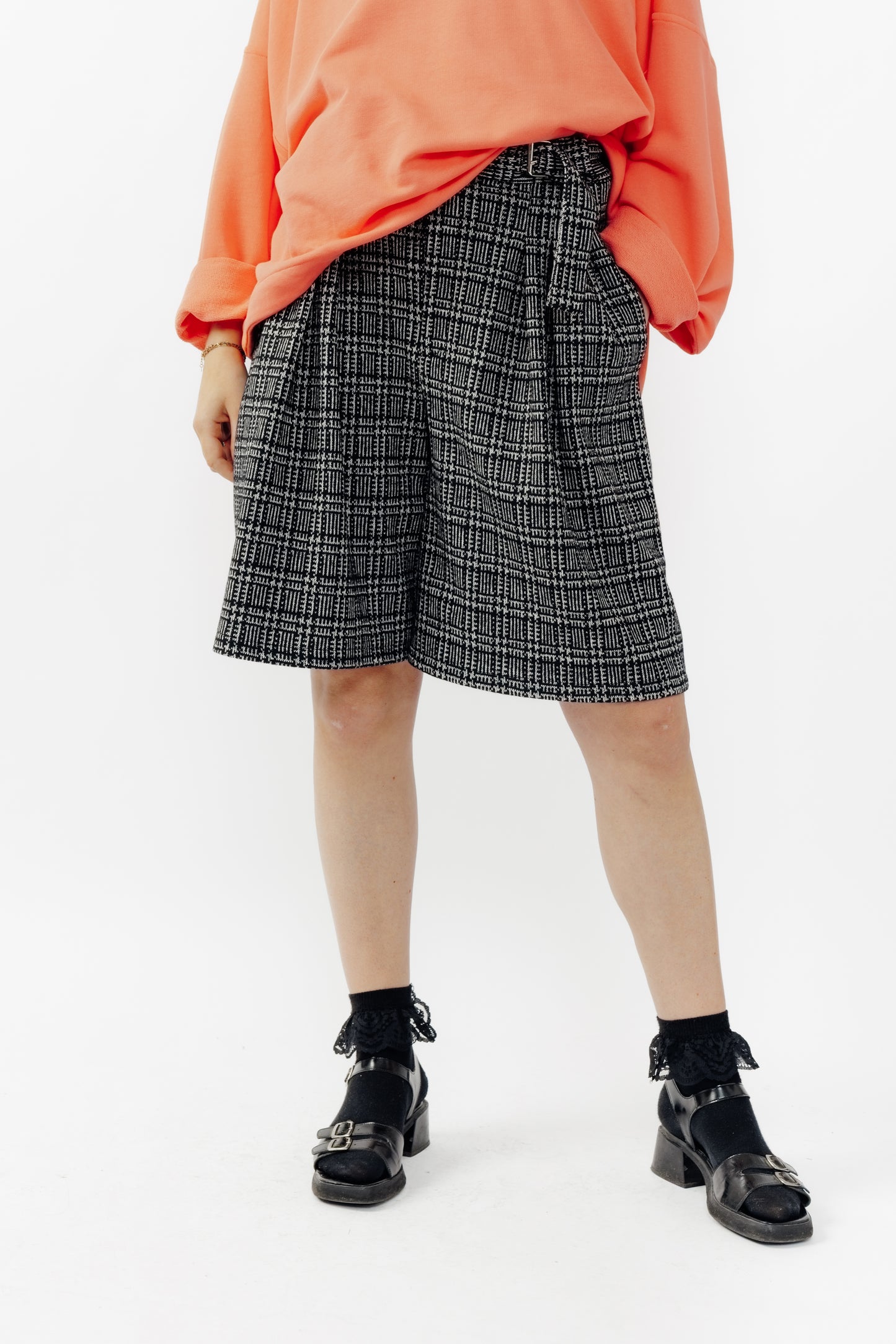 Short ballon de la marque Aïdama en laine à motif géométriques noirs et blancs avec ceinture ajustable. Porté par une mannequin femme et vu de face zoomé sur les jambes.