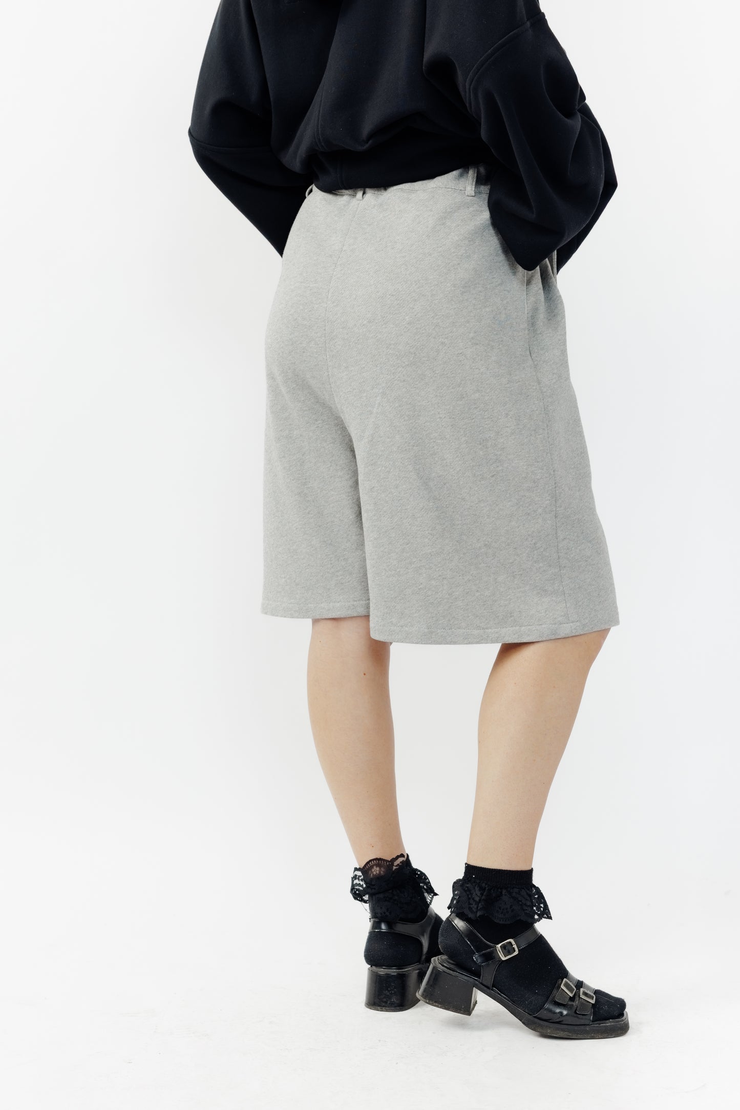 Short ballon de la marque Aïdama en laine à motif géométriques noirs et blancs avec ceinture ajustable. Porté par une mannequin femme et vu de dos.