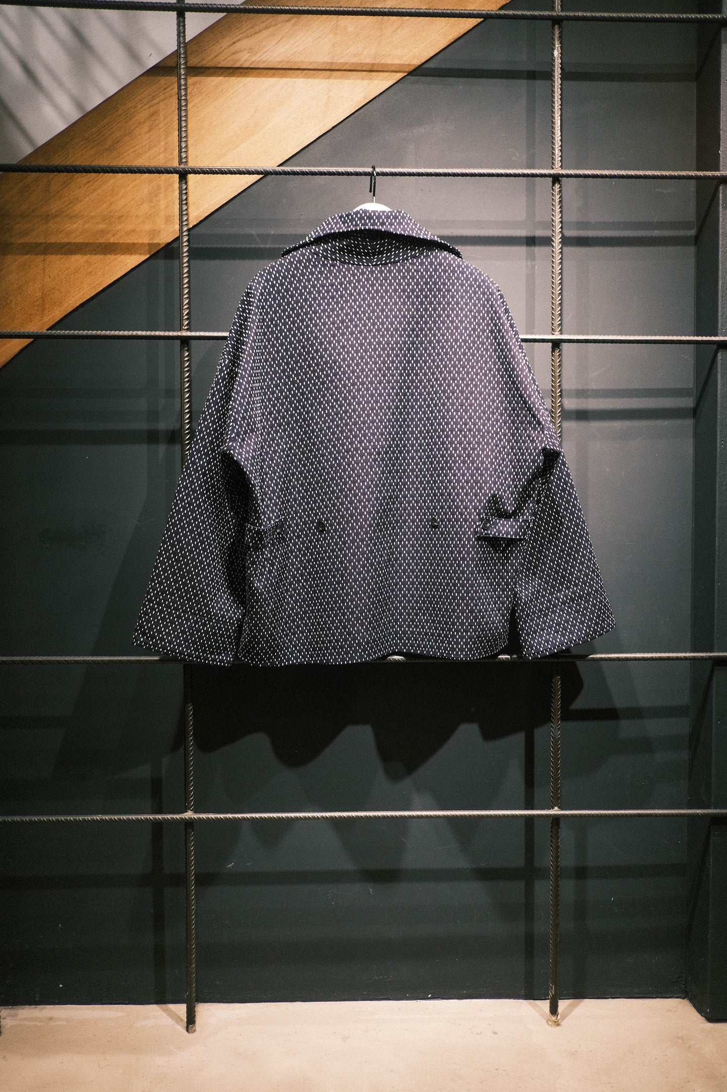 Veste oversize à col arrondi de la marque Aïdama, modèle Gunbai en coton japonais bleu brodé de points Sashiko. Vue sur ceintre et de dos.