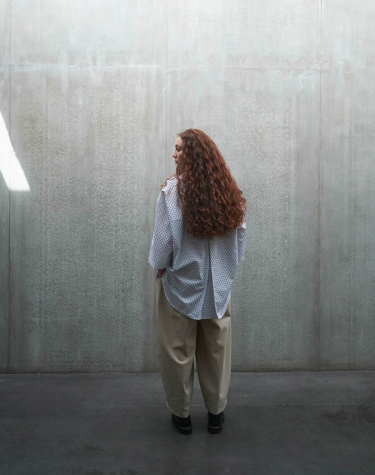 Chemise oversize à manches courtes et col club Aïdama modèle Marui en coton blanc à pois bleus. Portée par une mannequin femme et vue de dos.