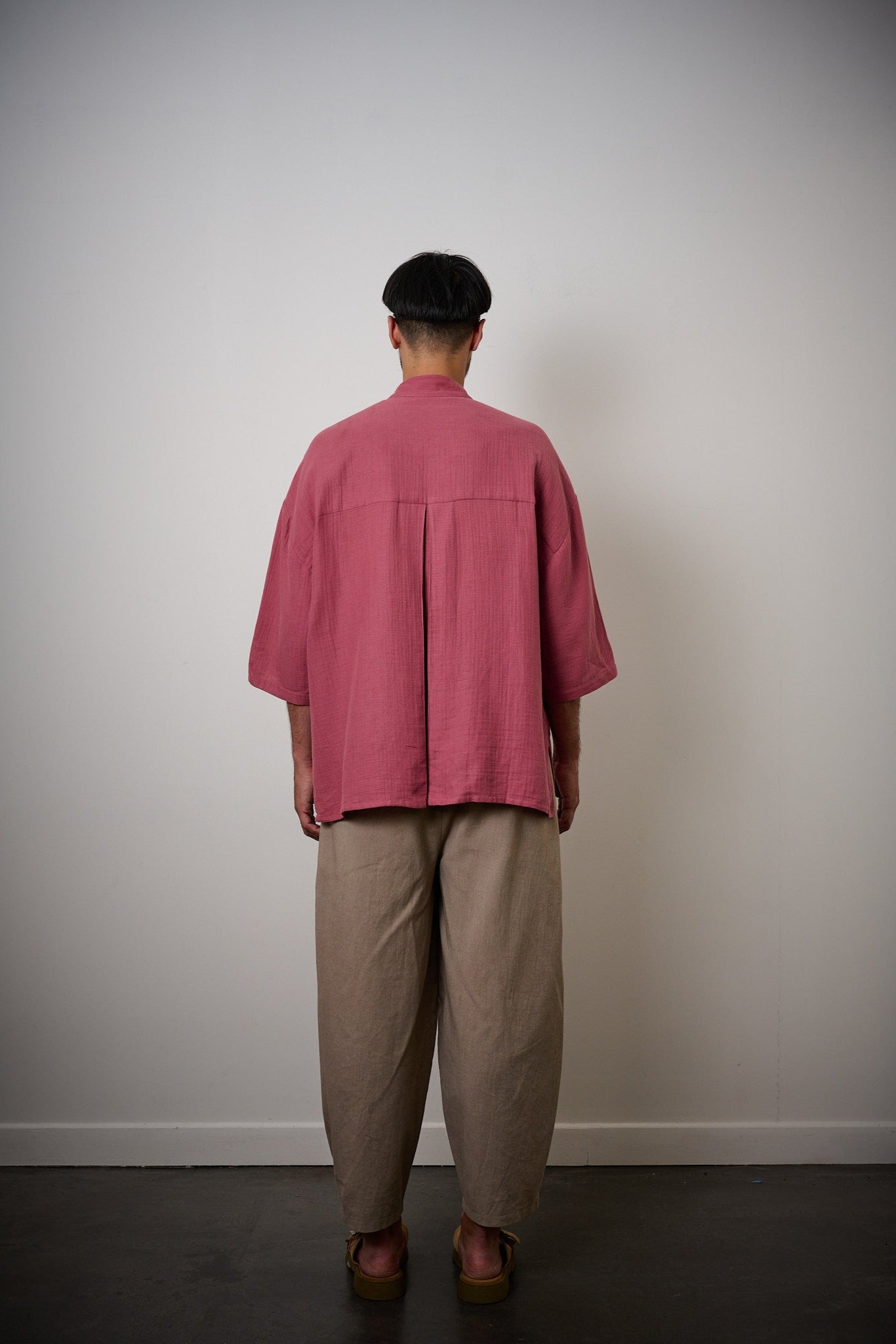 Chemise oversize à col officier de la marque aidama, modèle kita, coupe boxy en gaze de coton framboise. Portée par un mannequin homme et vu de dos.