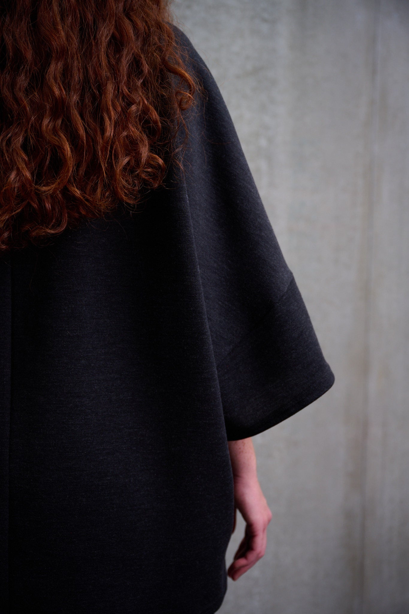 T-shirt oversize à col bateau Haku en laine gris quartz chiné de la marque Aïdama. Porté par une mannequin femme et vu zoomé sur la manche.