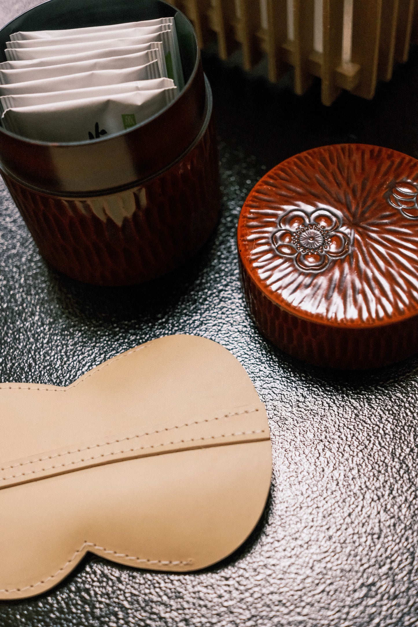 Tour de cou porte-cartes et porte-clés Hyotan de la marque Aïdama en cuir de vachette beige. Vue recto sur table.