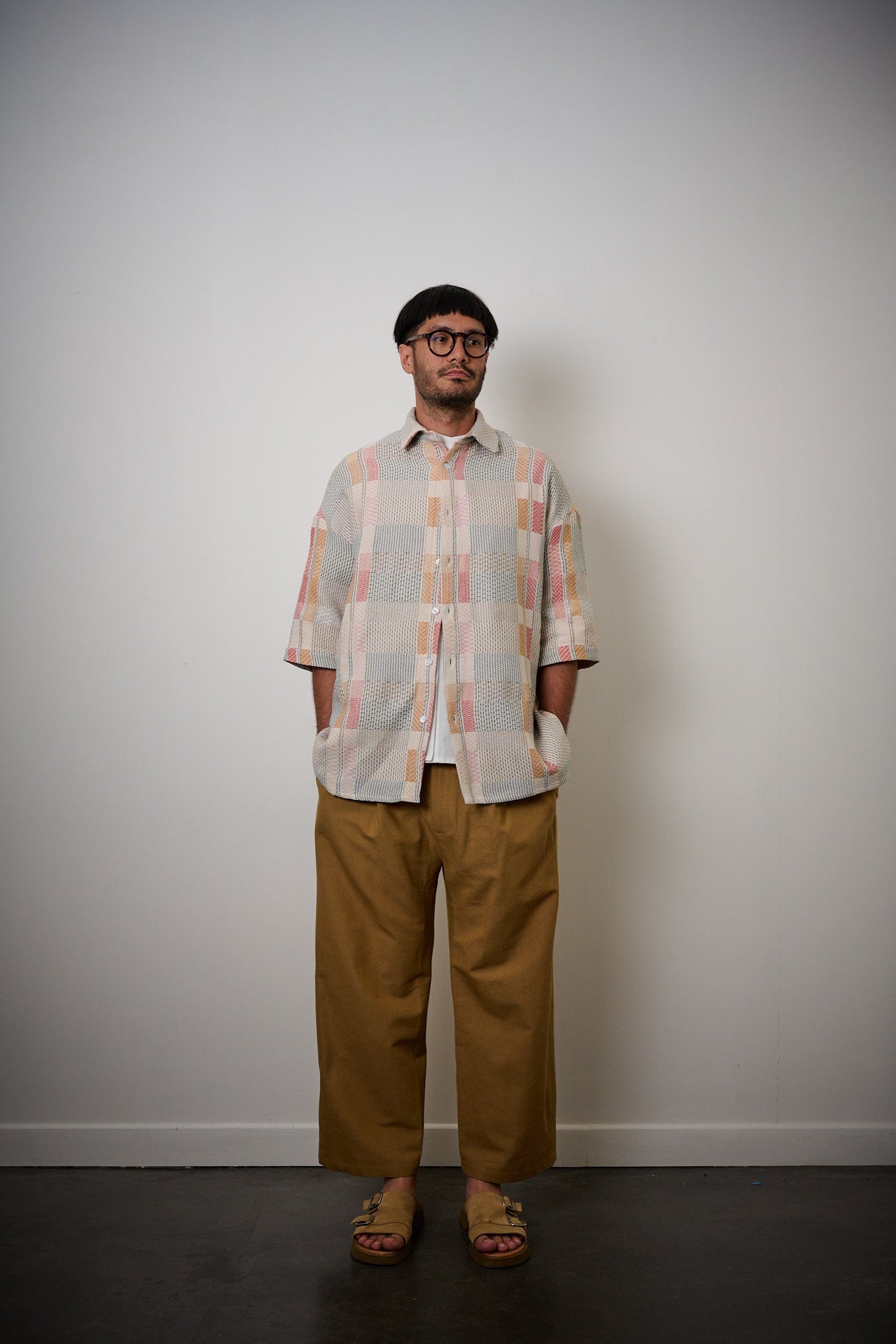 Chemise oversize à col club de la marque Aïdama en jacquard à carreaux fantaisies. Portée ouverte par un mannequin homme et vue de face. 