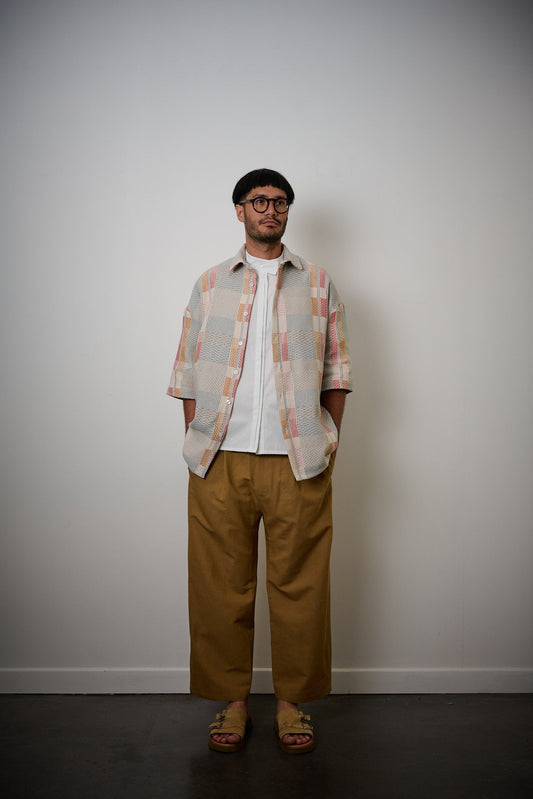 Chemise oversize à col club de la marque Aïdama en jacquard à carreaux fantaisies. Portée ouverte par un mannequin homme et vue de face. 