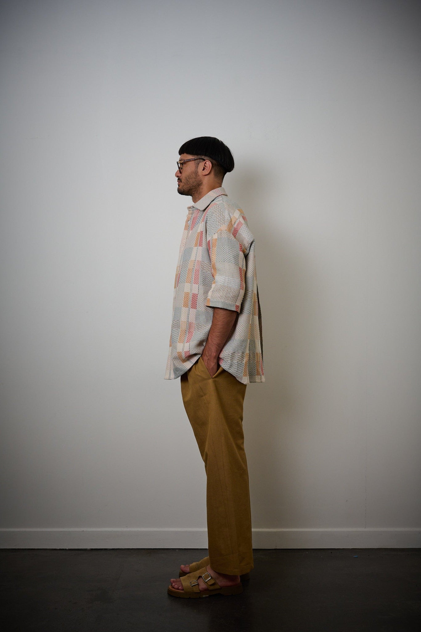 Chemise oversize à col club de la marque Aïdama en jacquard à carreaux fantaisies. Portée fermée par un mannequin homme et vue de profil.