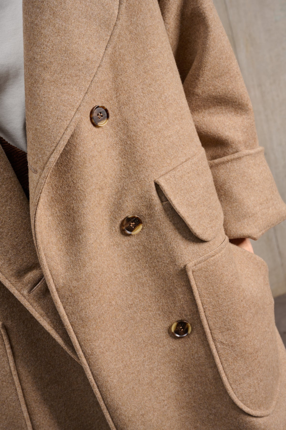 Manteau croisé oversize de la marque Aïdama, modèle Haomi en laine et cachemire beige. Porté ouvert et vu zoomé sur les boutons.