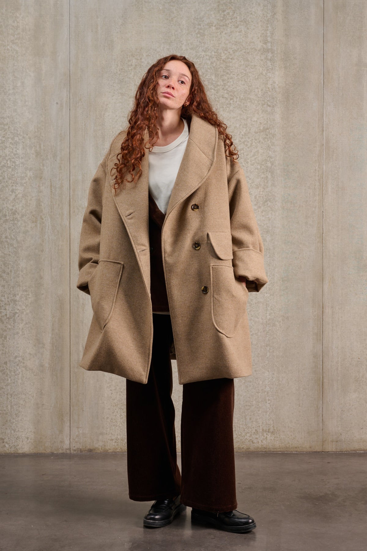 Manteau croisé oversize de la marque Aïdama, modèle Haomi en laine et cachemire beige. Porté ouvert par une mannequin femme et vu de face.