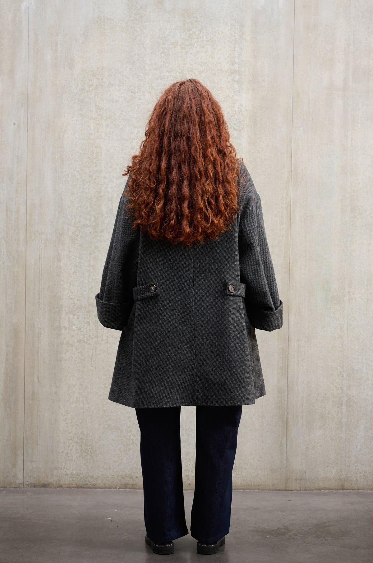 Manteau croisé oversize de la marque Aïdama, modèle Haomi en laine à micro motif damier gris et noir. Porté ouvert par une mannequin femme et vu de dos.