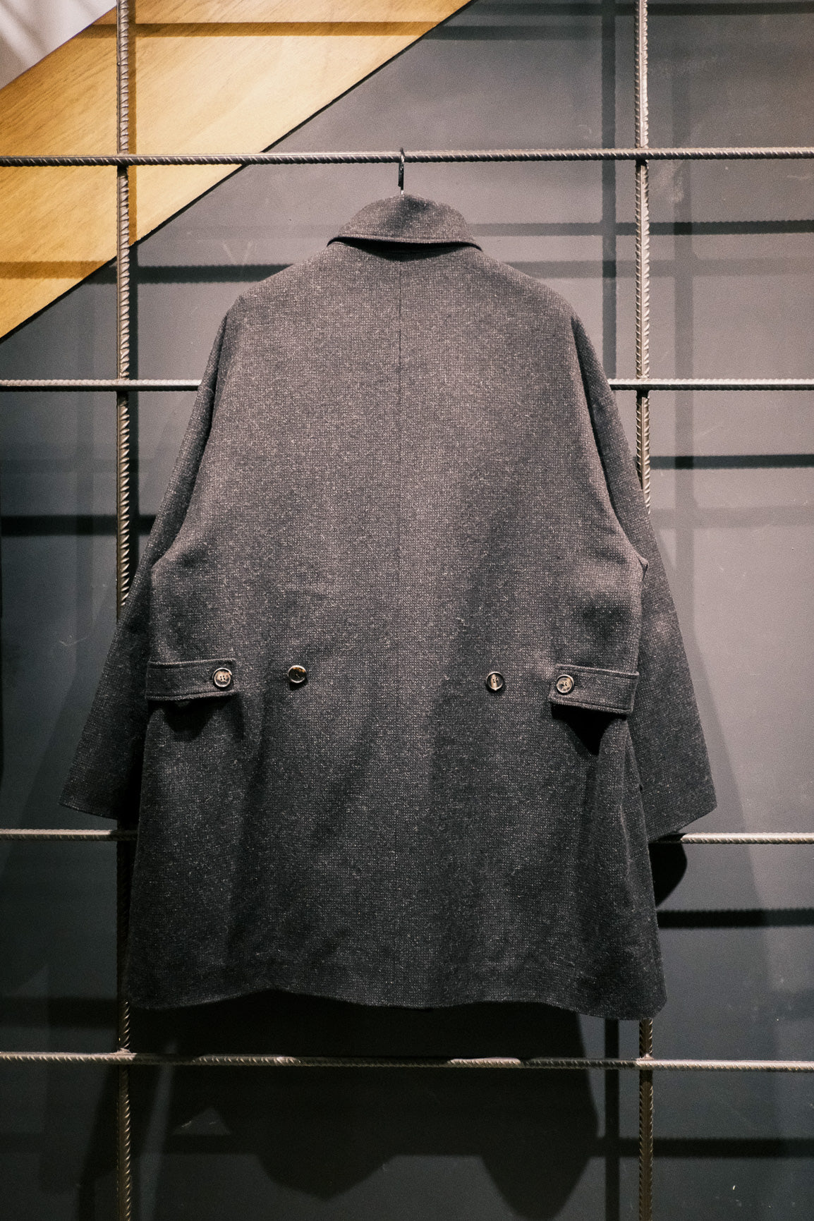 Manteau croisé oversize de la marque Aïdama, modèle Haomi en tweed de laine gris anthracite. Vue sur ceintre de dos.