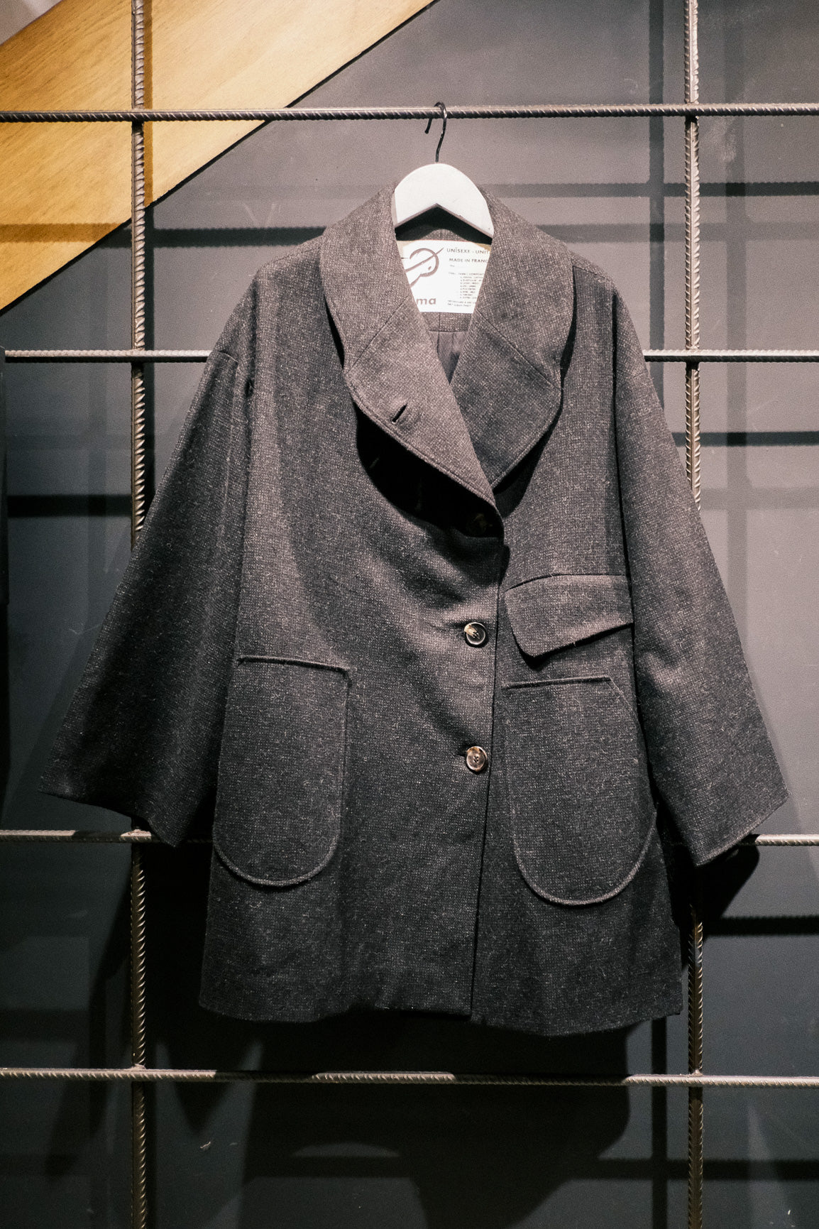 Manteau croisé oversize de la marque Aïdama, modèle Haomi en tweed de laine gris anthracite. Vu sur ceintre de face.