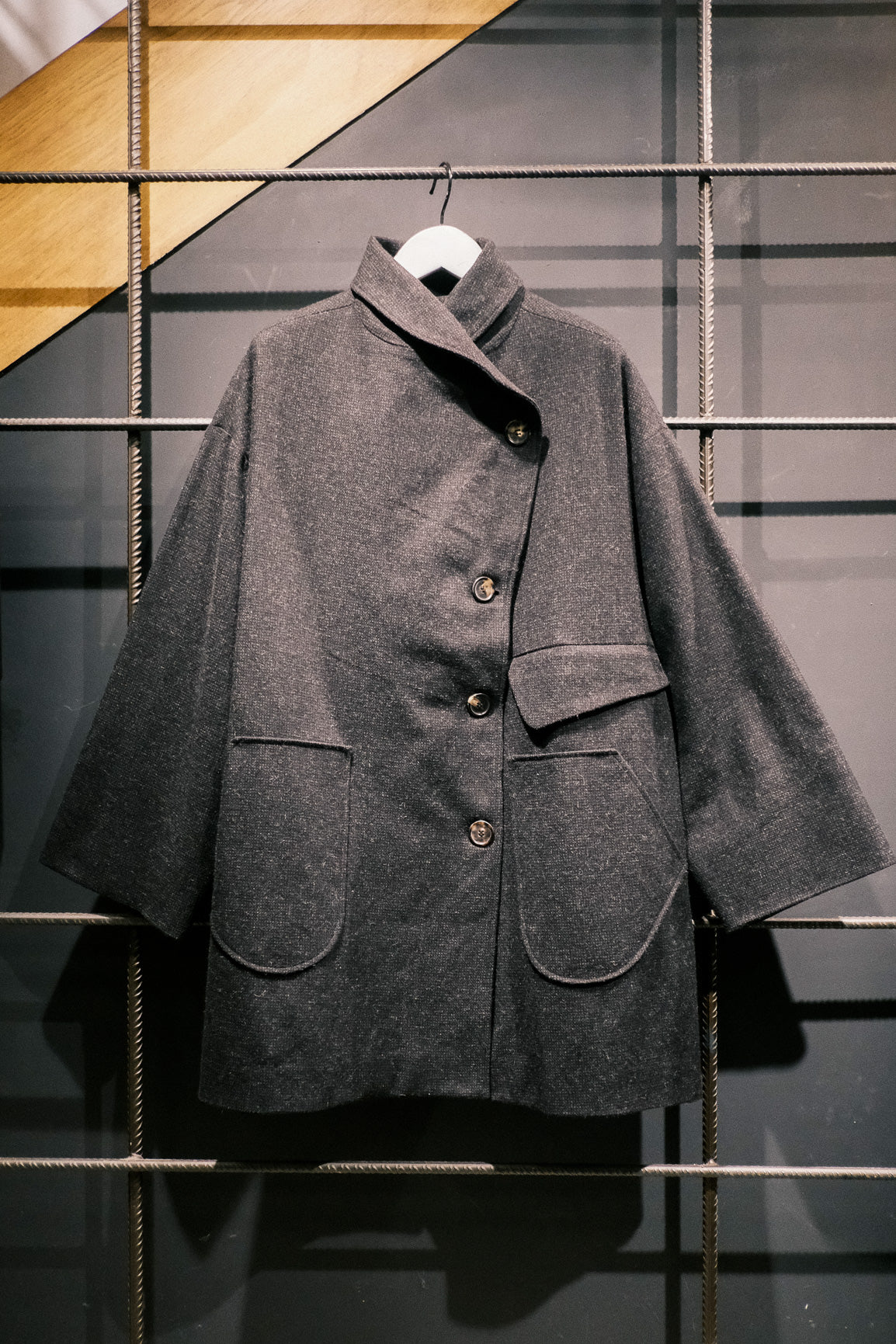 Manteau croisé oversize de la marque Aïdama, modèle Haomi en tweed de laine gris anthracite. Vue sur ceintre de face.