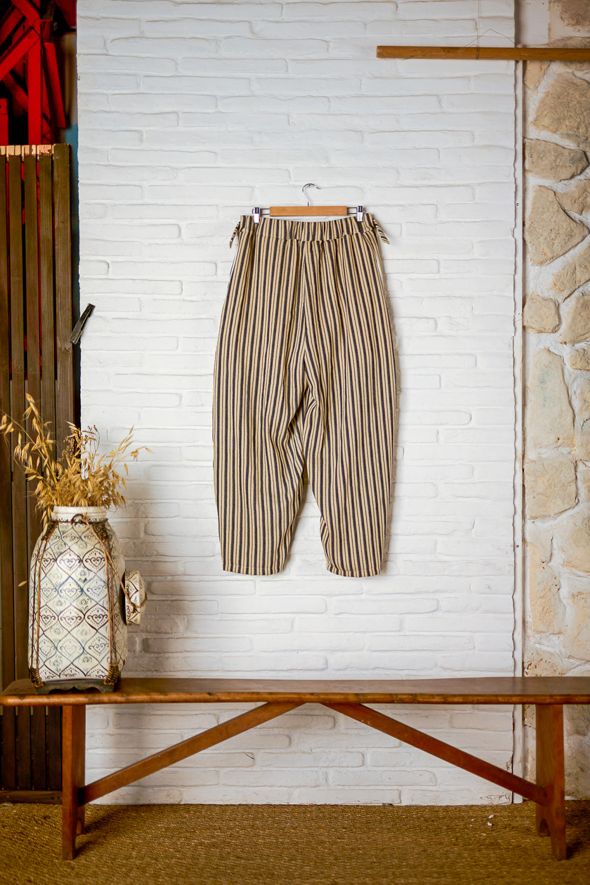 Pantalon circulaire de la marque Aïdama, coupe ballon en coton crème à rayures noires. Vu de dos sur fond blanc.