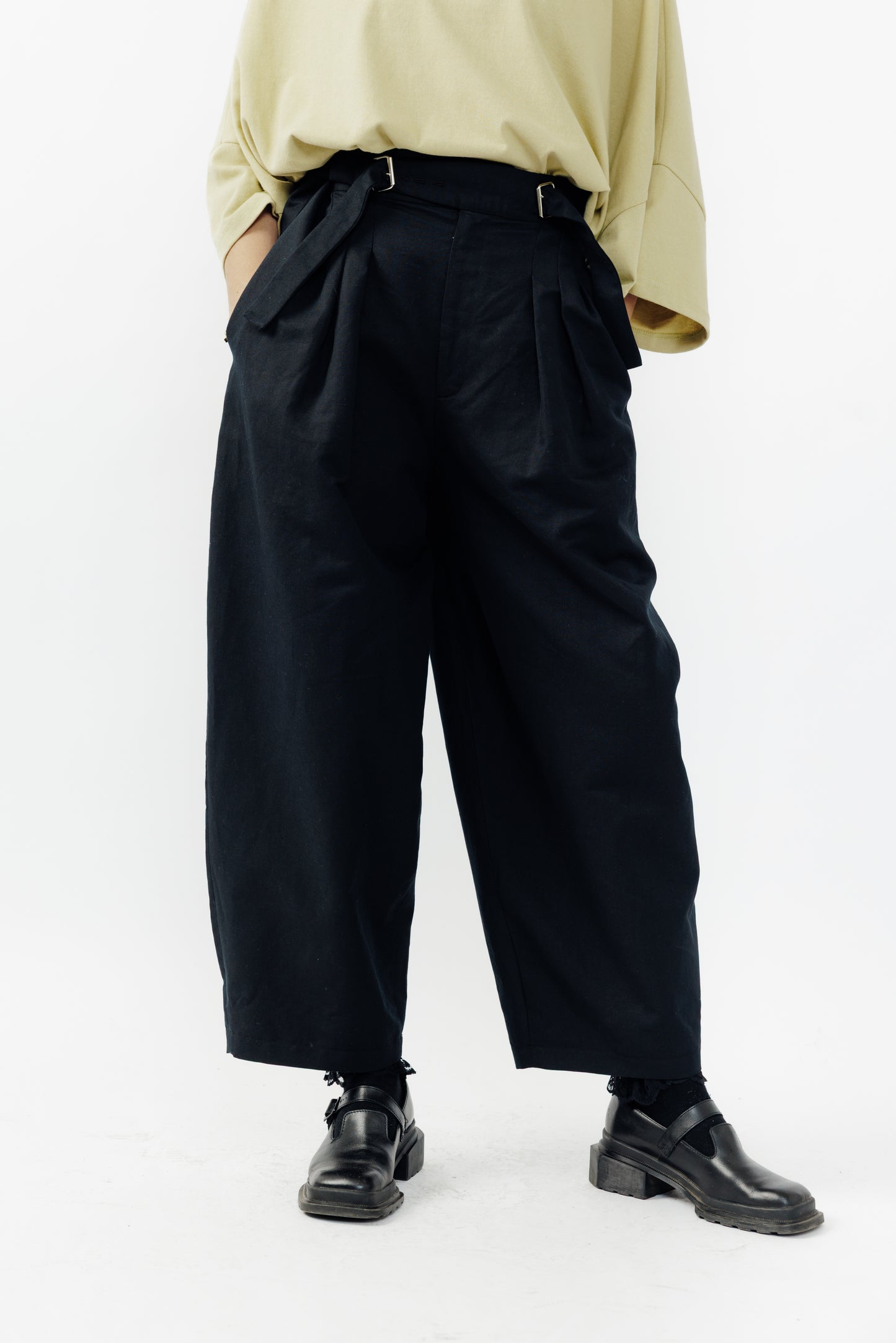 Pantalon circulaire de la marque Aïdama, coupe ballon en coton et lin noir avec ceinture ajustable. Porté par une mannequin femme et vu zoomé sur les jambes.
