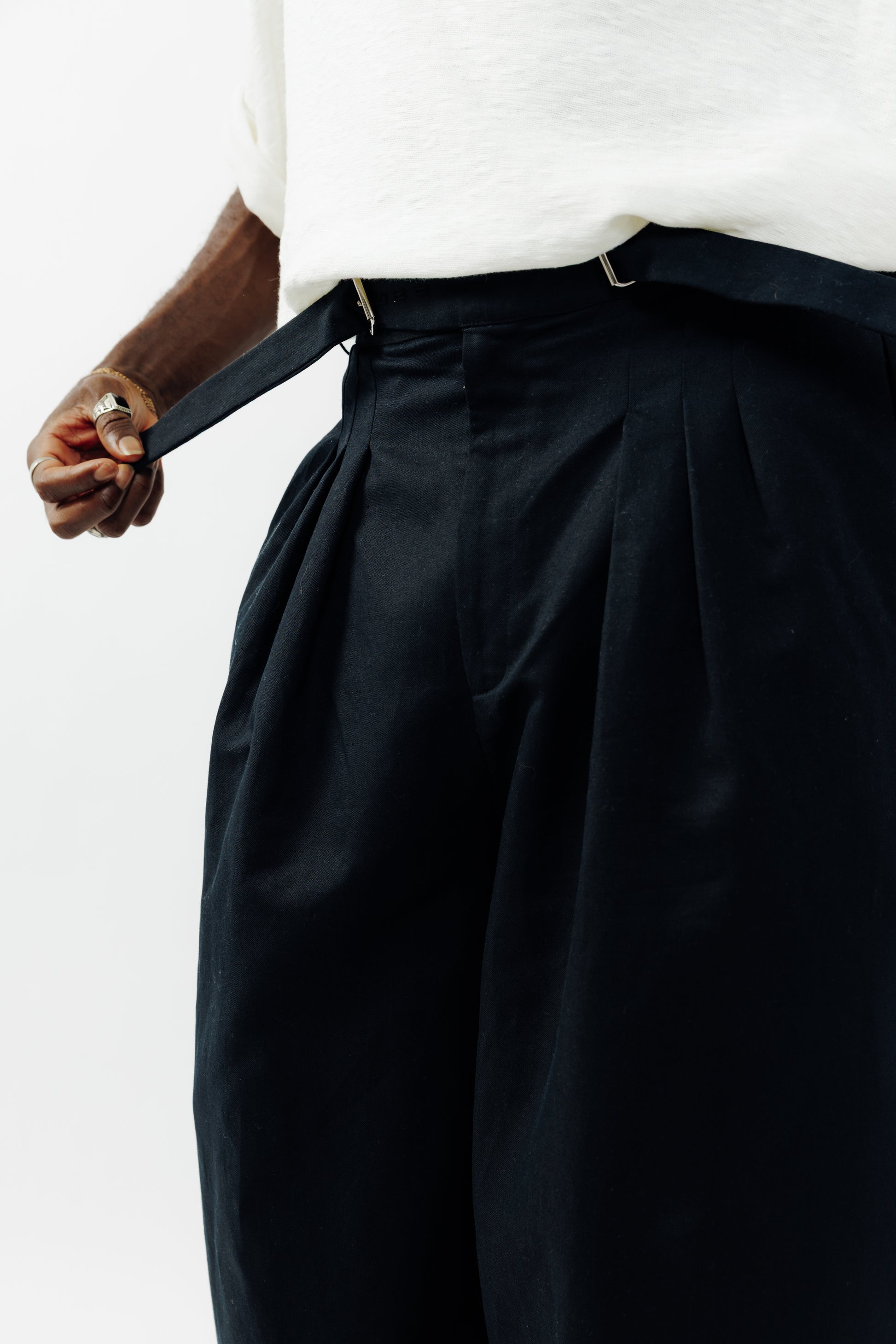 Pantalon circulaire de la marque Aïdama, coupe ballon en coton et lin noir avec ceinture ajustable. Porté par un mannequin homme et vu zoomé sur la ceinture.