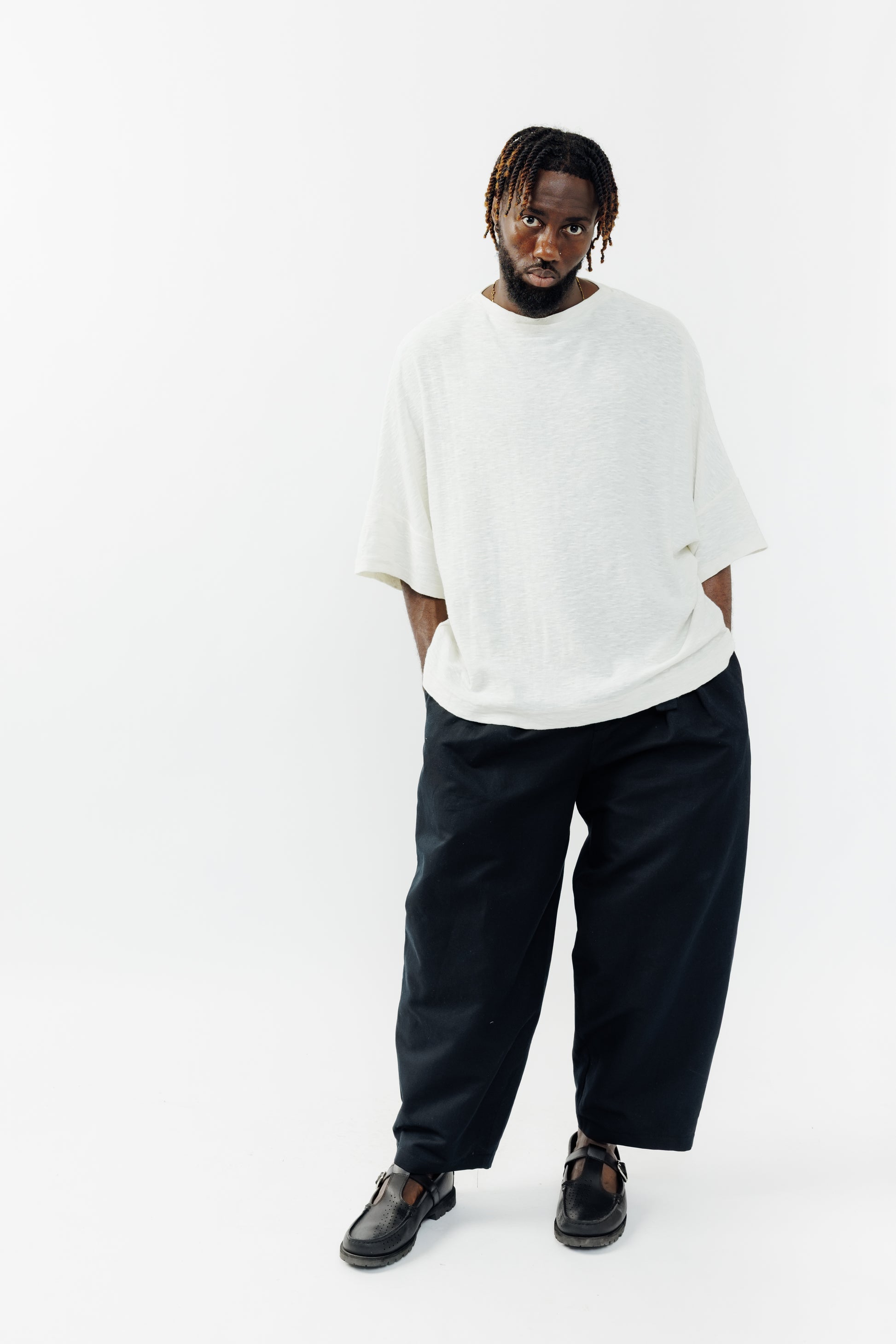 Pantalon circulaire de la marque Aïdama, coupe ballon en coton et lin noir avec ceinture ajustable. Porté par un mannequin homme et vu de face.