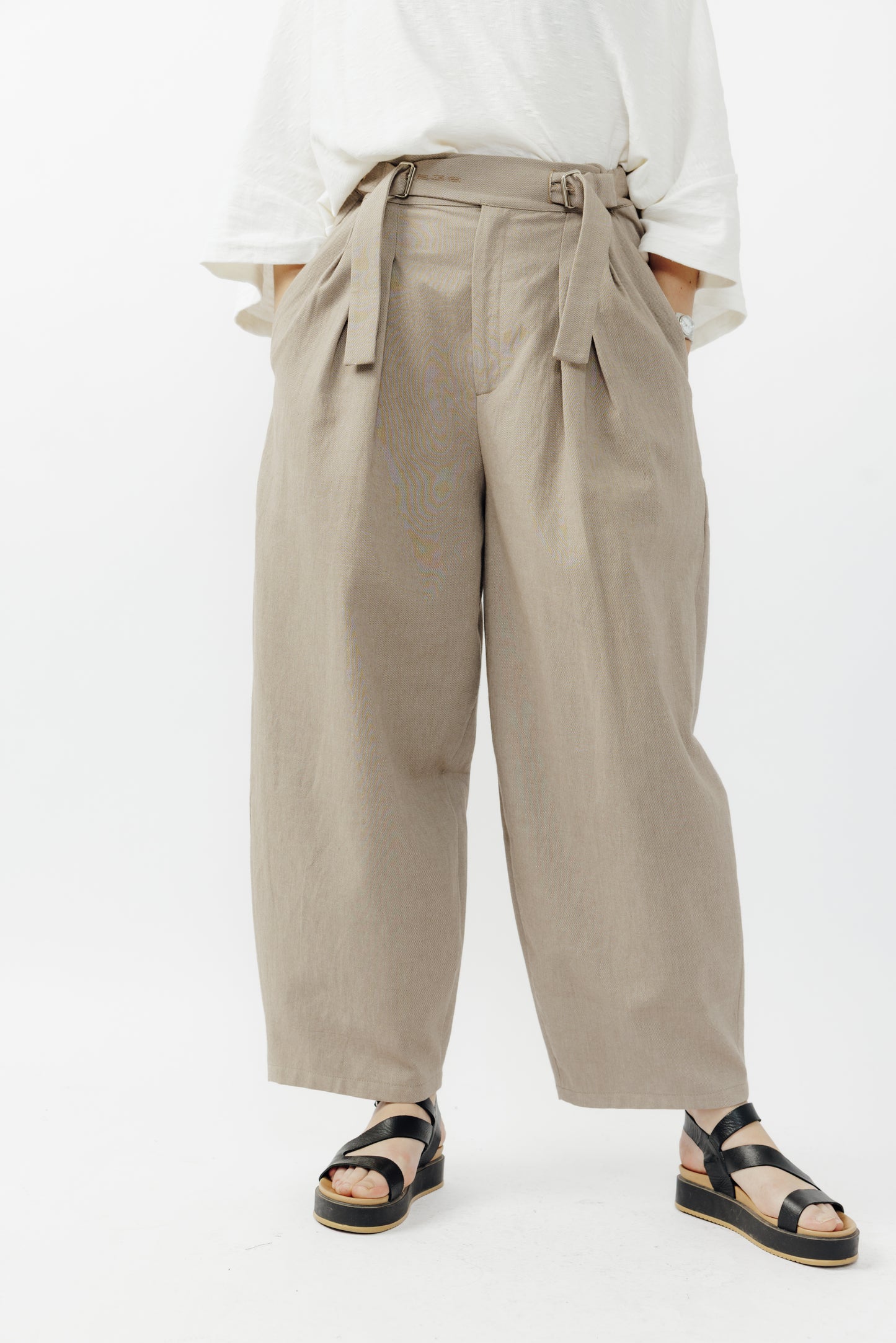 Pantalon circulaire de la marque Aïdama, coupe ballon en coton marron glacé avec ceinture ajustable. Porté par une mannequin femme et vu de face zoomé sur les jambes.