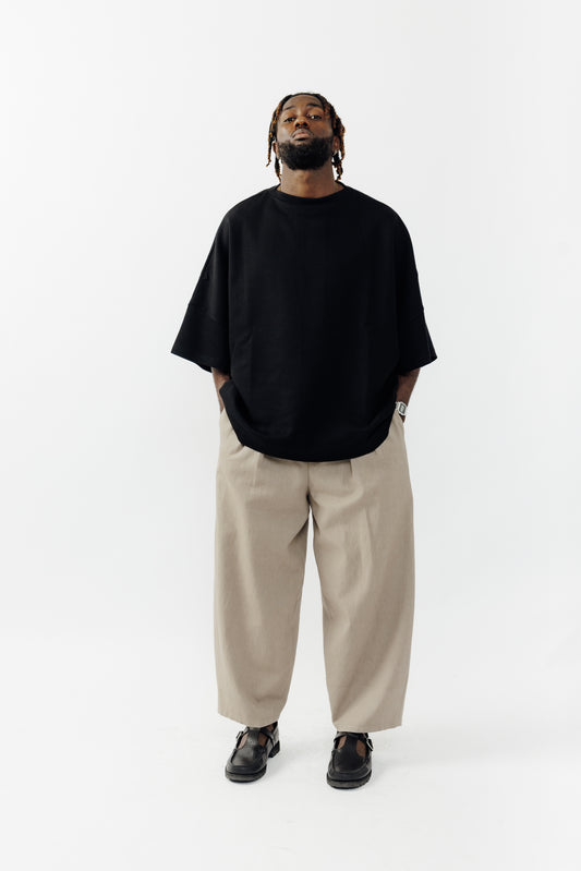 Pantalon circulaire de la marque Aïdama, coupe ballon en coton marron glacé avec ceinture ajustable. Porté par un mannequin homme et vu de face.