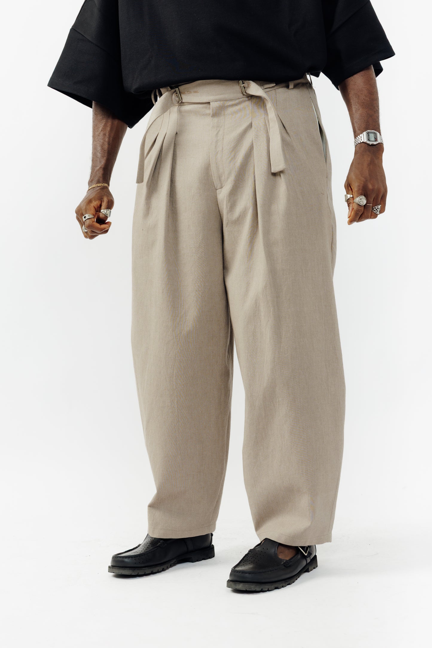 Pantalon circulaire de la marque Aïdama, coupe ballon en coton marron glacé avec ceinture ajustable. Porté par un mannequin homme et vu de face zoomé sur les jambes.