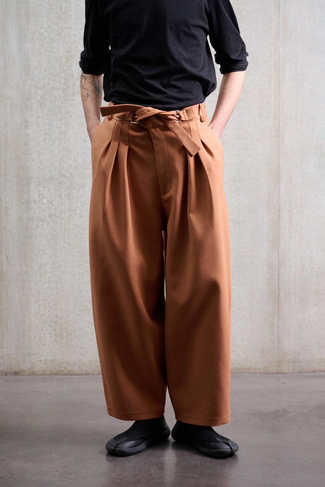 Pantalon circulaire Aïdama, coupe ballon avec ceinture ajustable en coton & laine terre de sienne. Porté par un mannequin homme et vu de face.