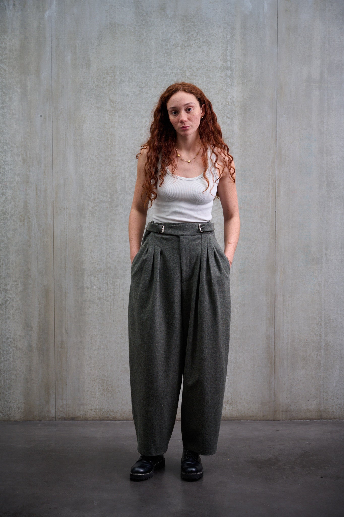 Pantalon circulaire Aïdama, coupe ballon avec ceinture ajustable en flanelle de laine gris chiné. Porté par une mannequin femme et vu de face.