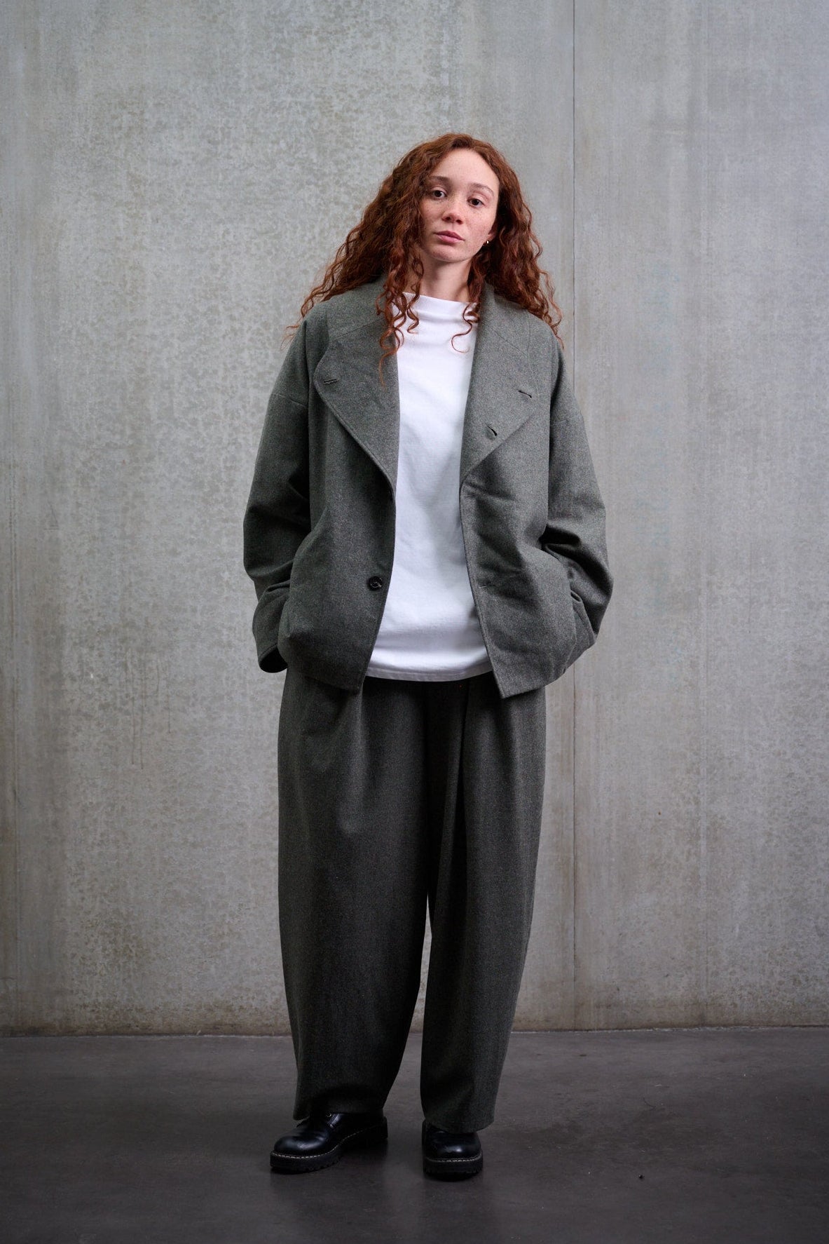 Pantalon circulaire Aïdama, coupe ballon avec ceinture ajustable en flanelle de laine gris chiné. Porté par une mannequin femme et vu de face.