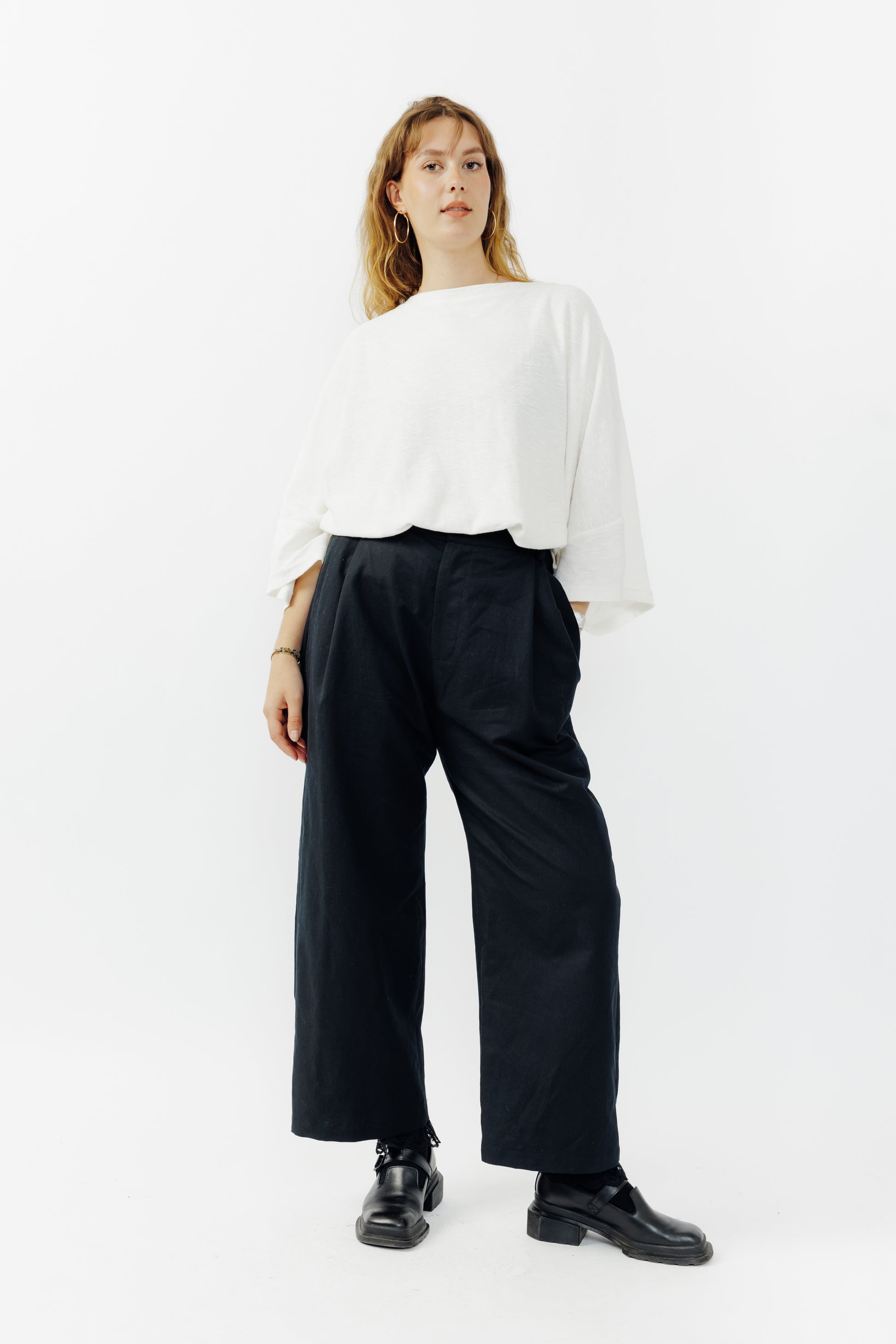 Pantalon droit de la marque Aïdama, coupe ample en coton et lin noir avec sangles ajustables à la taille. Porté par une mannequin femme et vu de face.
