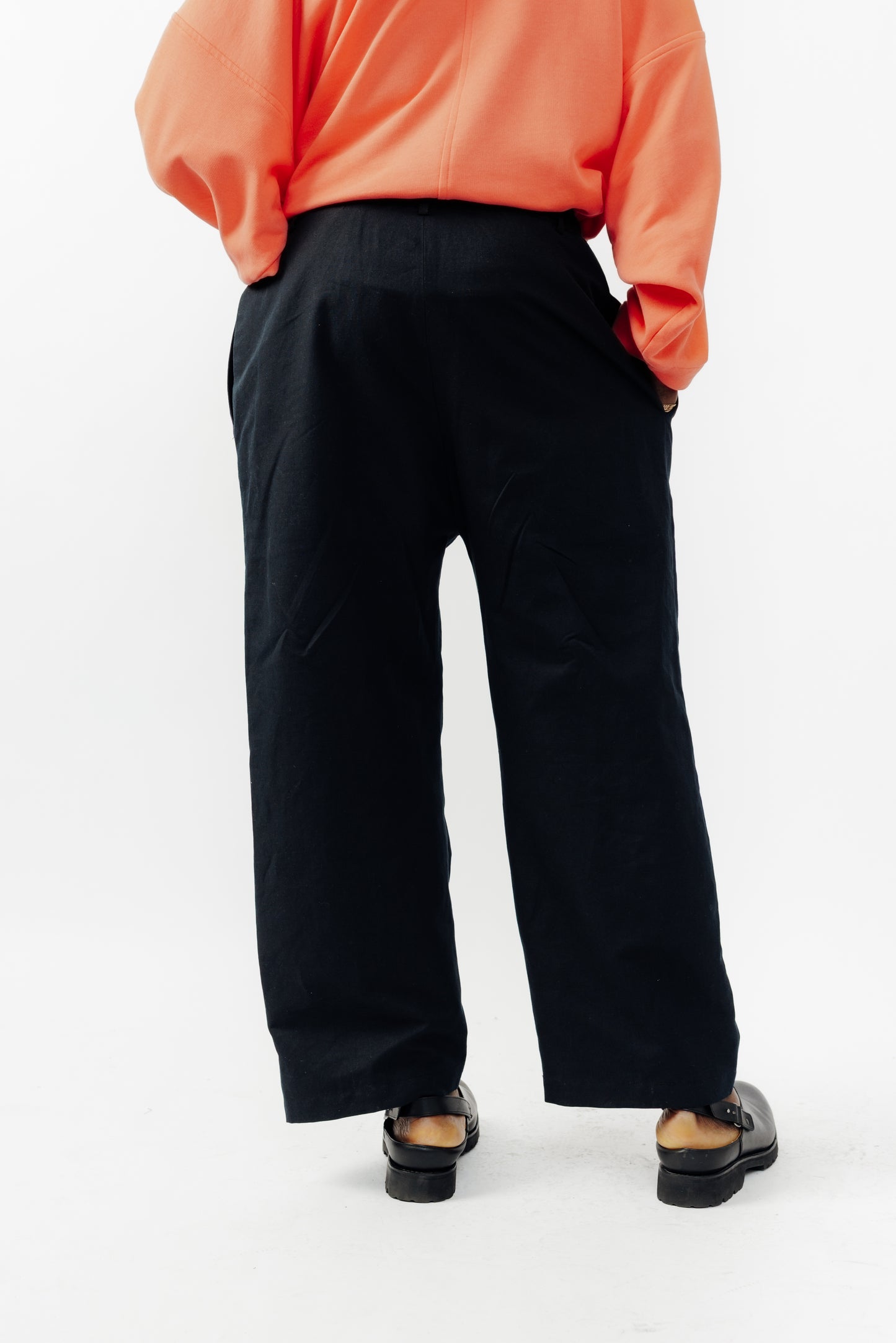 Pantalon droit de la marque Aïdama, coupe ample en coton et lin noir avec sangles ajustables à la taille. Porté par un mannequin homme et vu de dos.
