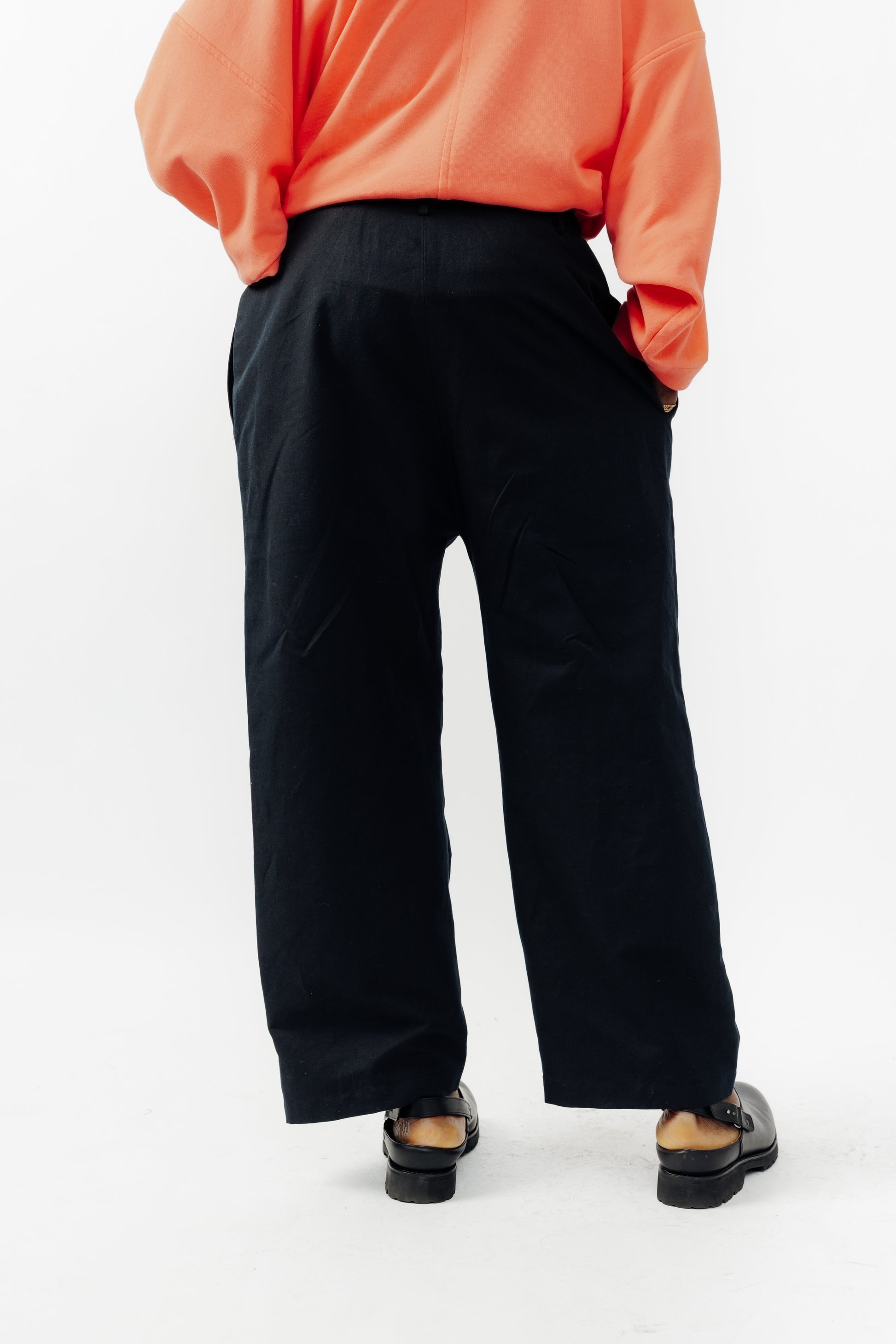 Pantalon droit de la marque Aïdama, coupe ample en coton et lin noir avec sangles ajustables à la taille. Porté par un mannequin homme et vu de dos.