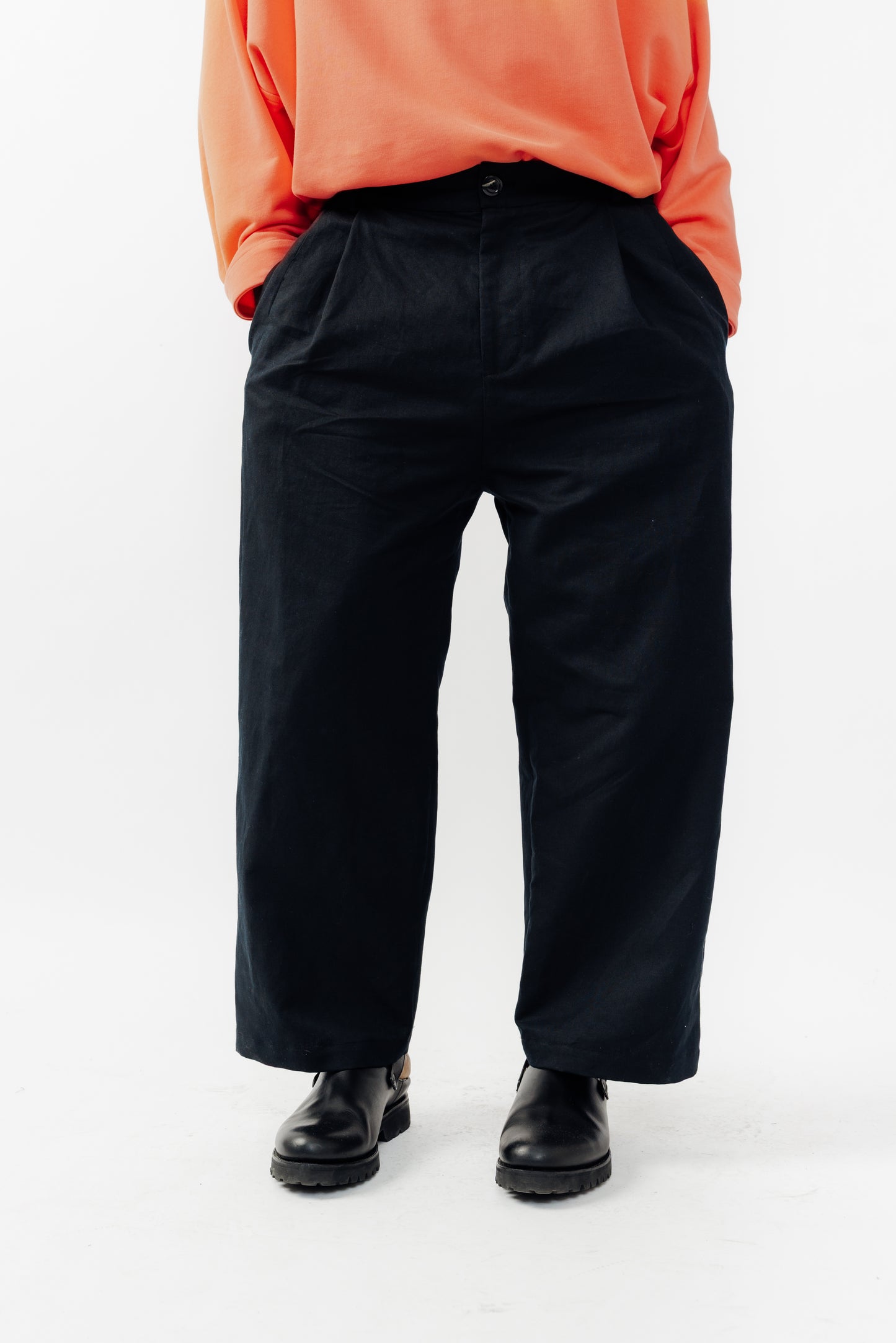 Pantalon droit de la marque Aïdama, coupe ample en coton et lin noir avec sangles ajustables à la taille. Porté par un mannequin homme et vu de face zoomé sur les jambes.