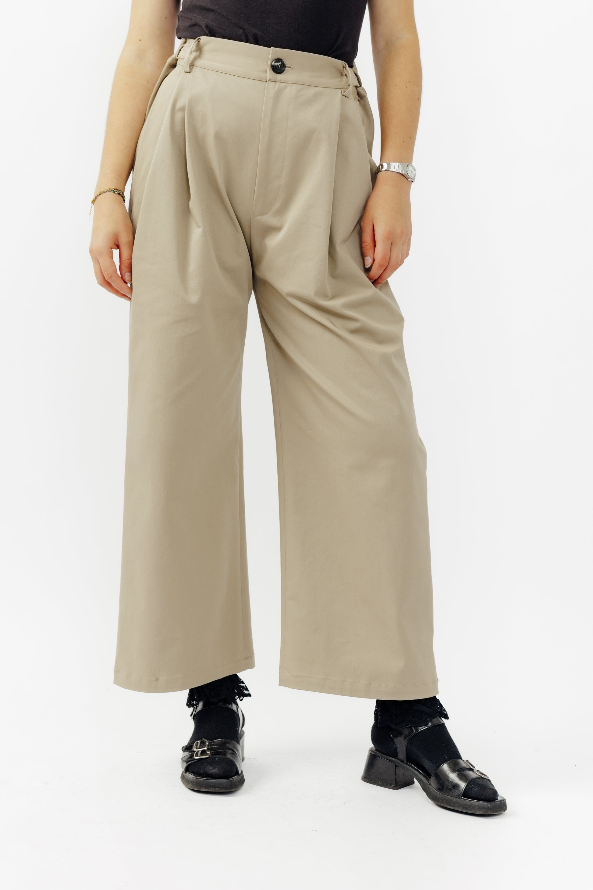 Pantalon droit de la marque Aïdama, coupe ample en gabardine de coton beige avec sangles ajustables à la taille. Porté par une mannequin femme et vu de face.