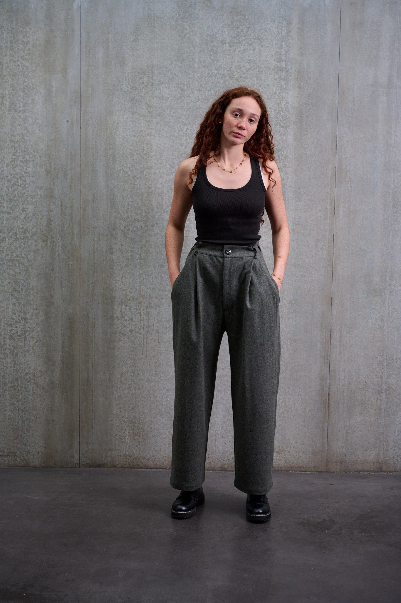 Pantalon droit de la marque Aïdama, coupe large en flanelle de laine grise. Porté par une mannequin femme et vu de face.