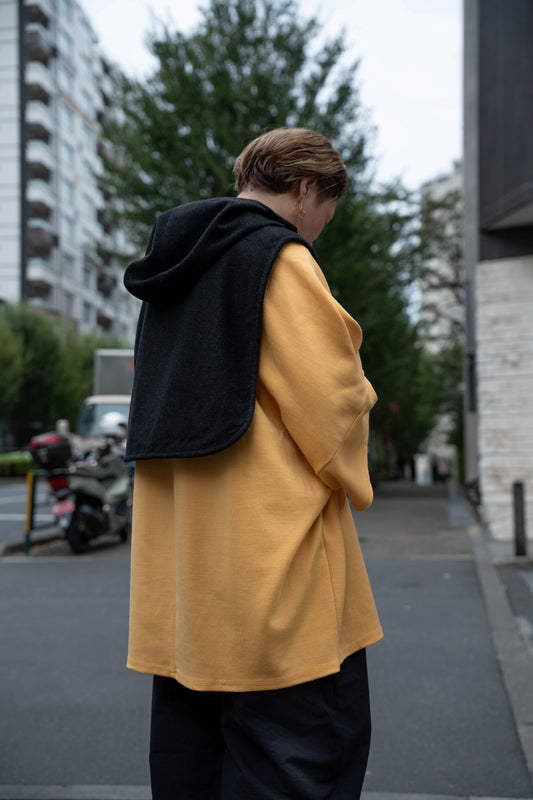 Plastron à capuche de la marque Aïdama, modèle Do en laine noire. Porté par une mannequin femme et vu de dos.