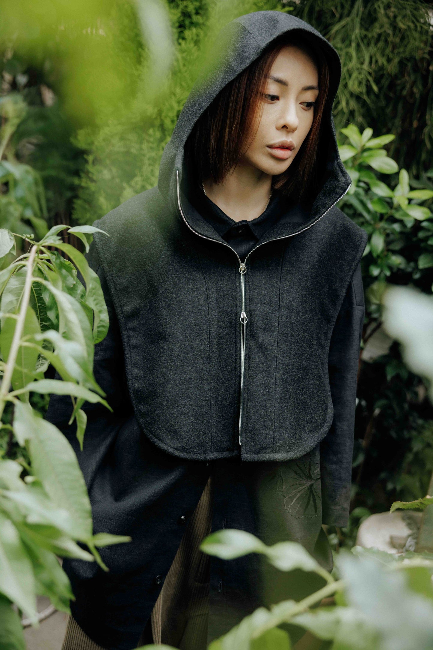 Plastron à capuche de la marque Aïdama, modèle Do en laine noire. Porté capuche relevée, par une mannequin femme et vu de face.