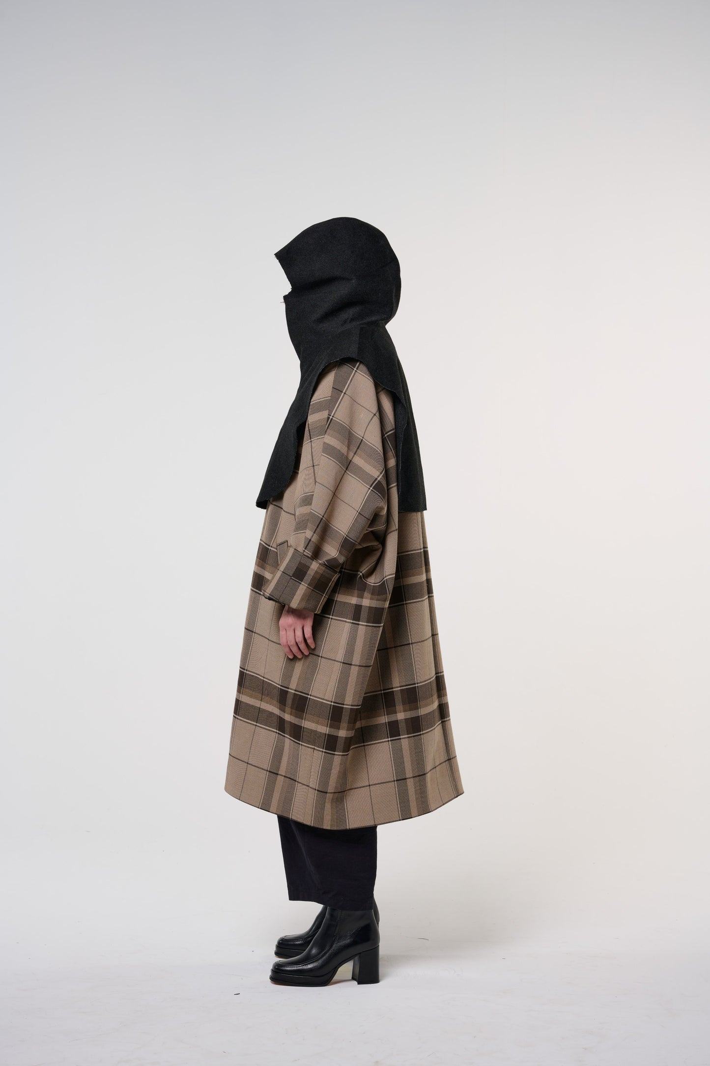 Plastron à capuche de la marque Aïdama, modèle Do en laine noire. Porté capuche relevée par une mannequin femme et vu de face. 