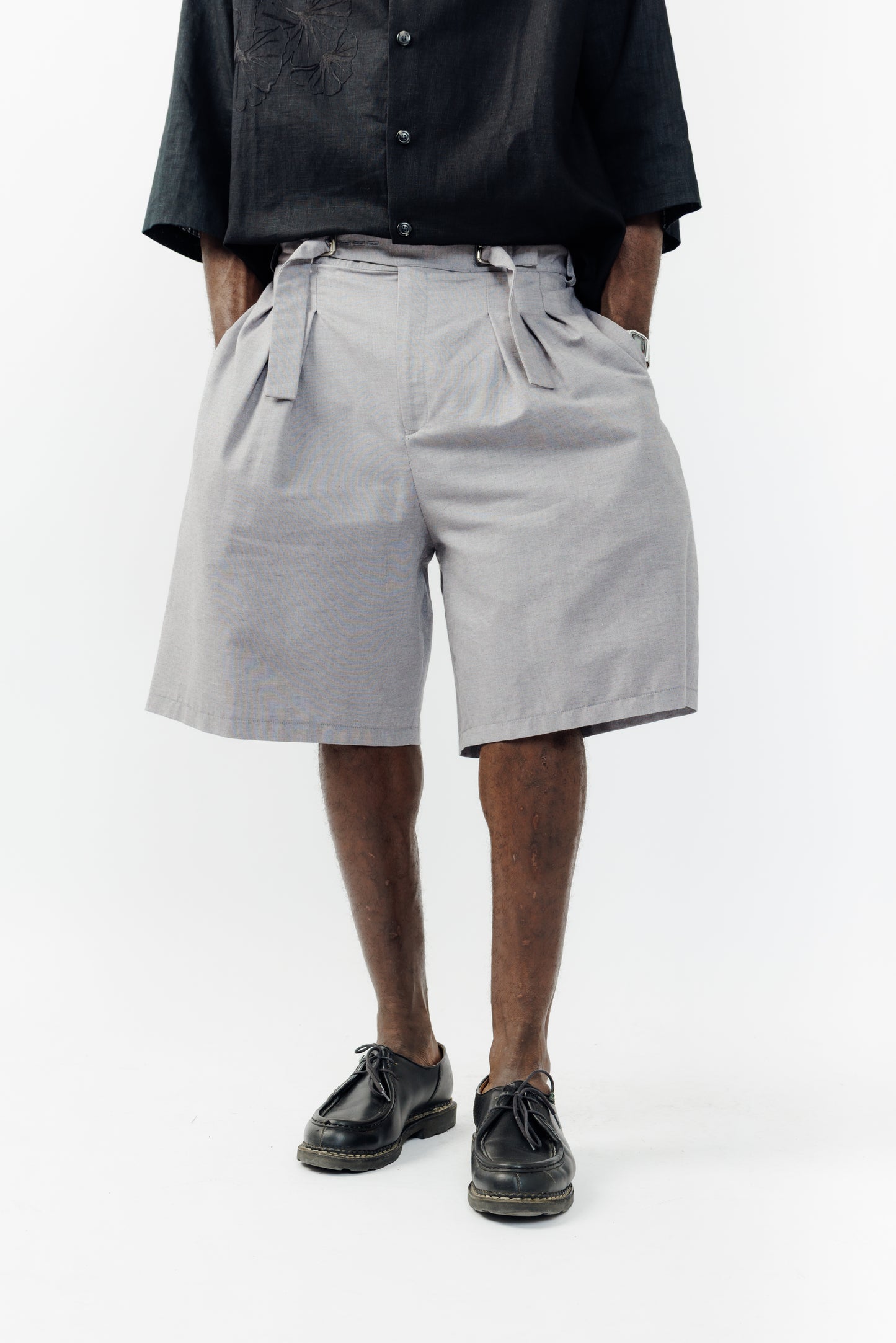 Short ballon de la marque Aïdama en coton lavande-gris à motif chevrons avec ceinture ajustable. Porté par un mannequin homme et vu de face.