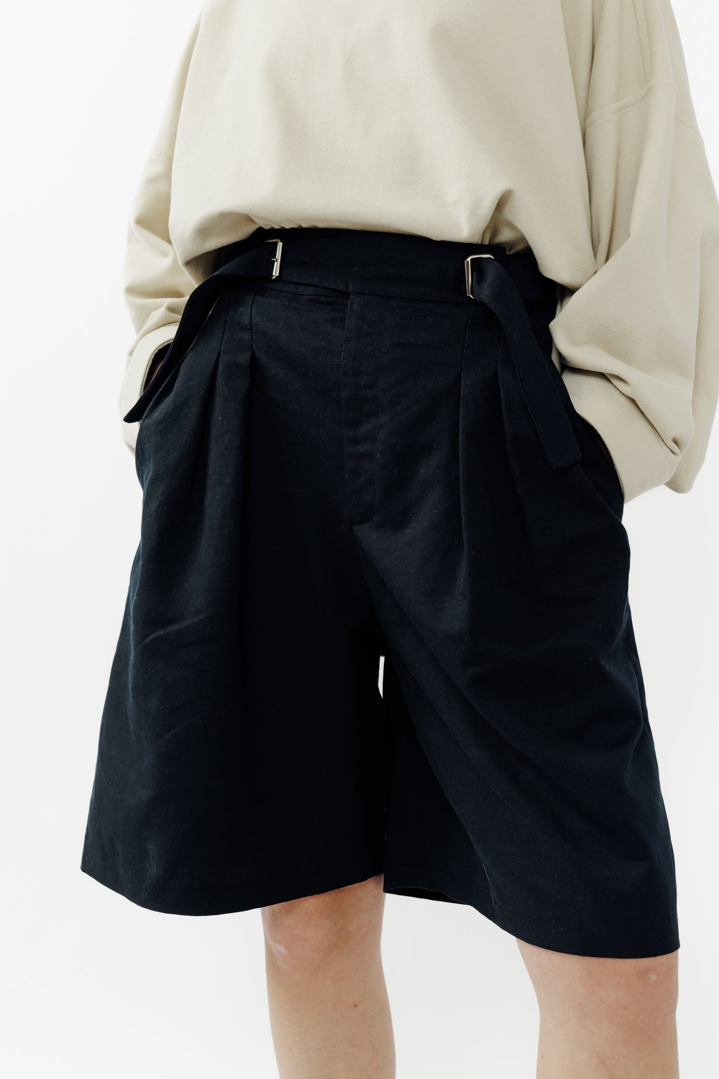 Short ballon de la marque Aïdama en coton & lin noir avec ceinture ajustable. Porté par une mannequin femme et vu zoomé.