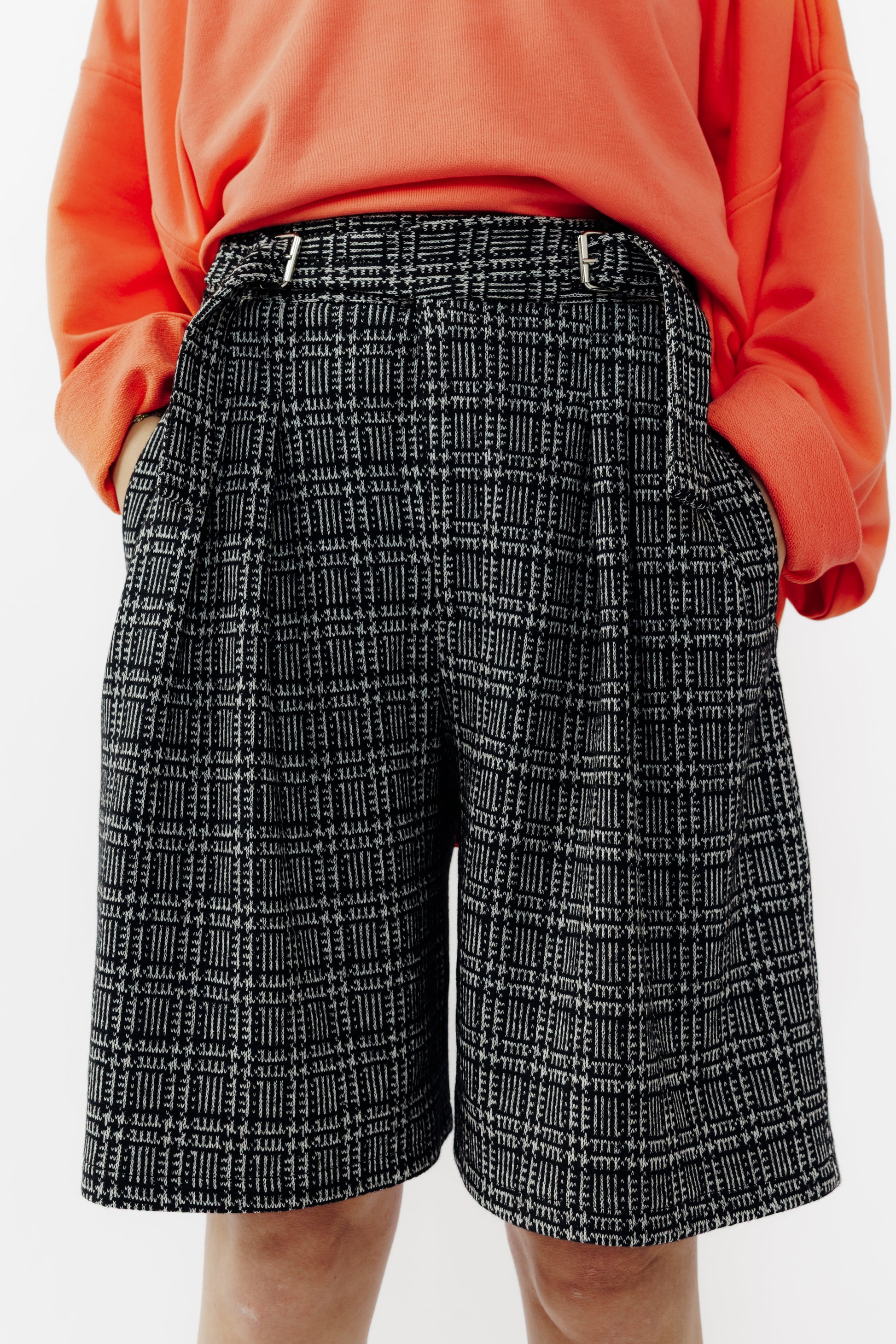 Short ballon de la marque Aïdama en laine à motif géométriques noirs et blancs avec ceinture ajustable. Porté par une mannequin femme et vu de face zoomé sur la ceinture.
