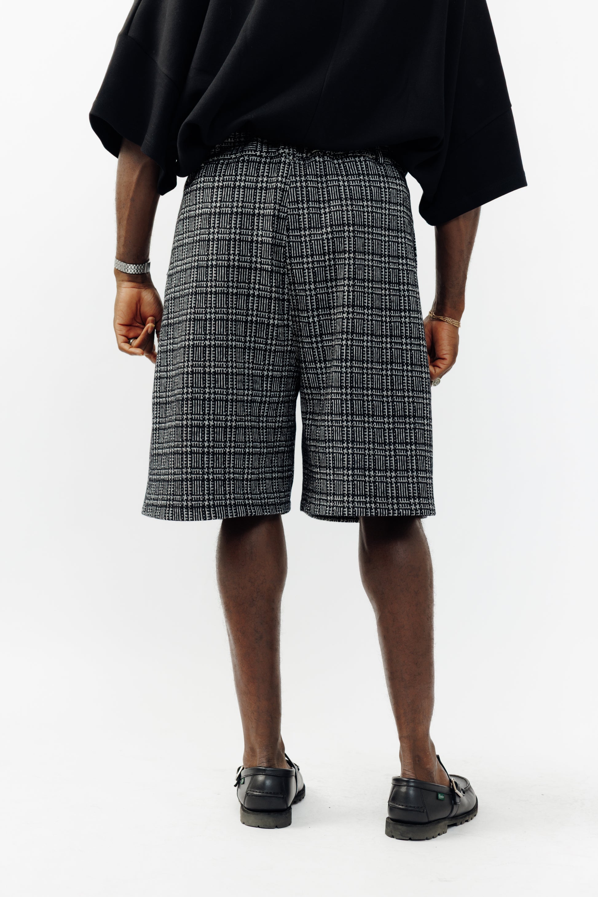 Short ballon de la marque Aïdama en laine à motif géométriques noirs et blancs avec ceinture ajustable. Porté par un mannequin homme et vu de dos.
