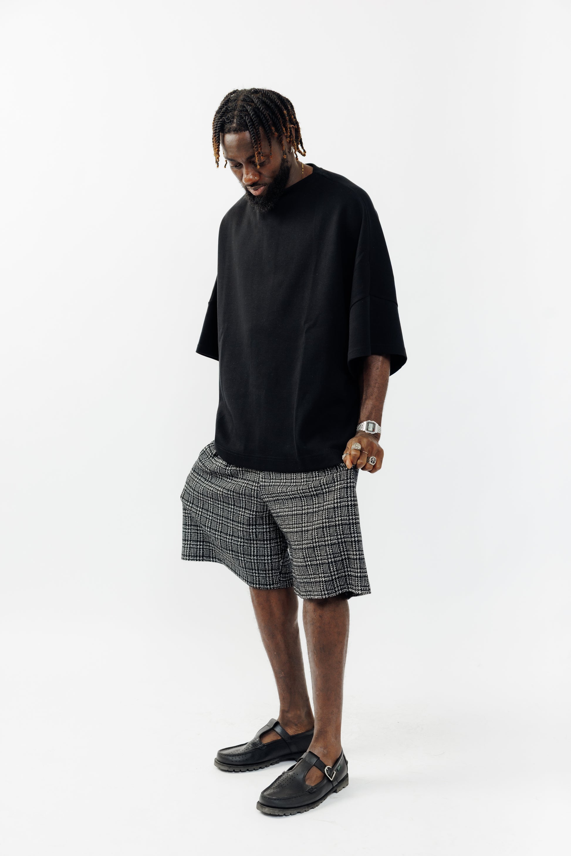 Short ballon de la marque Aïdama en laine à motif géométriques noirs et blancs avec ceinture ajustable. Porté par un mannequin homme et vu de face.