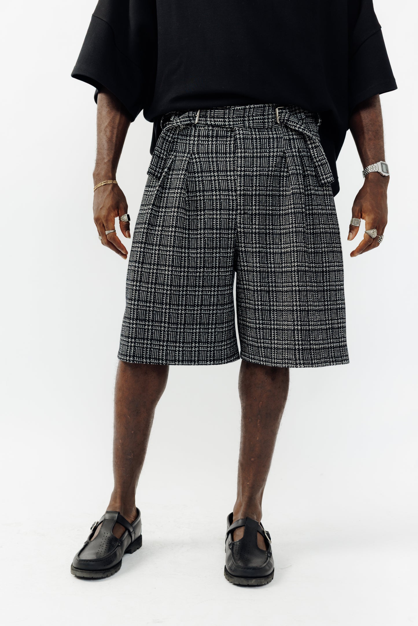 Short ballon de la marque Aïdama en laine à motif géométriques noirs et blancs avec ceinture ajustable. Porté par un mannequin homme et vu zoomé sur les jambes.
