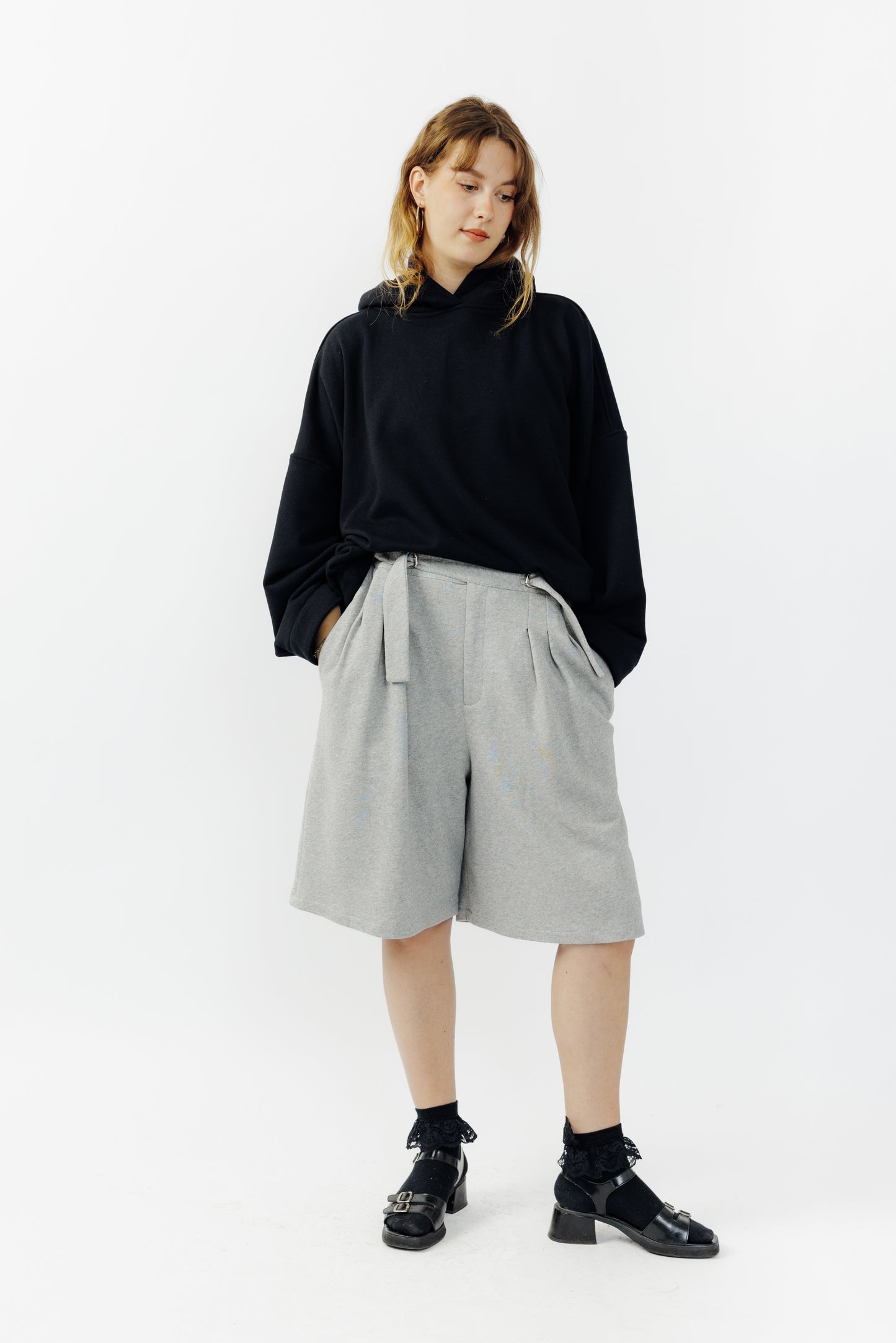 Short ballon de la marque Aïdama en laine à motif géométriques noirs et blancs avec ceinture ajustable. Porté par une mannequin femme et vu de face.