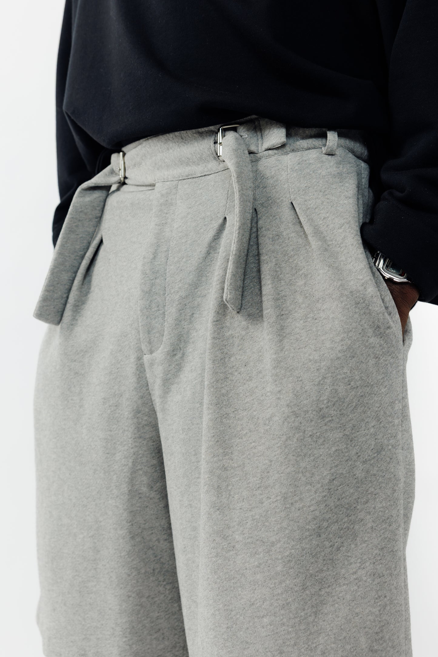 Short ballon de la marque Aïdama en molleton de coton gris chiné avec ceinture ajustable. Porté par un mannequin homme et vu de face zoomé sur la ceinture.