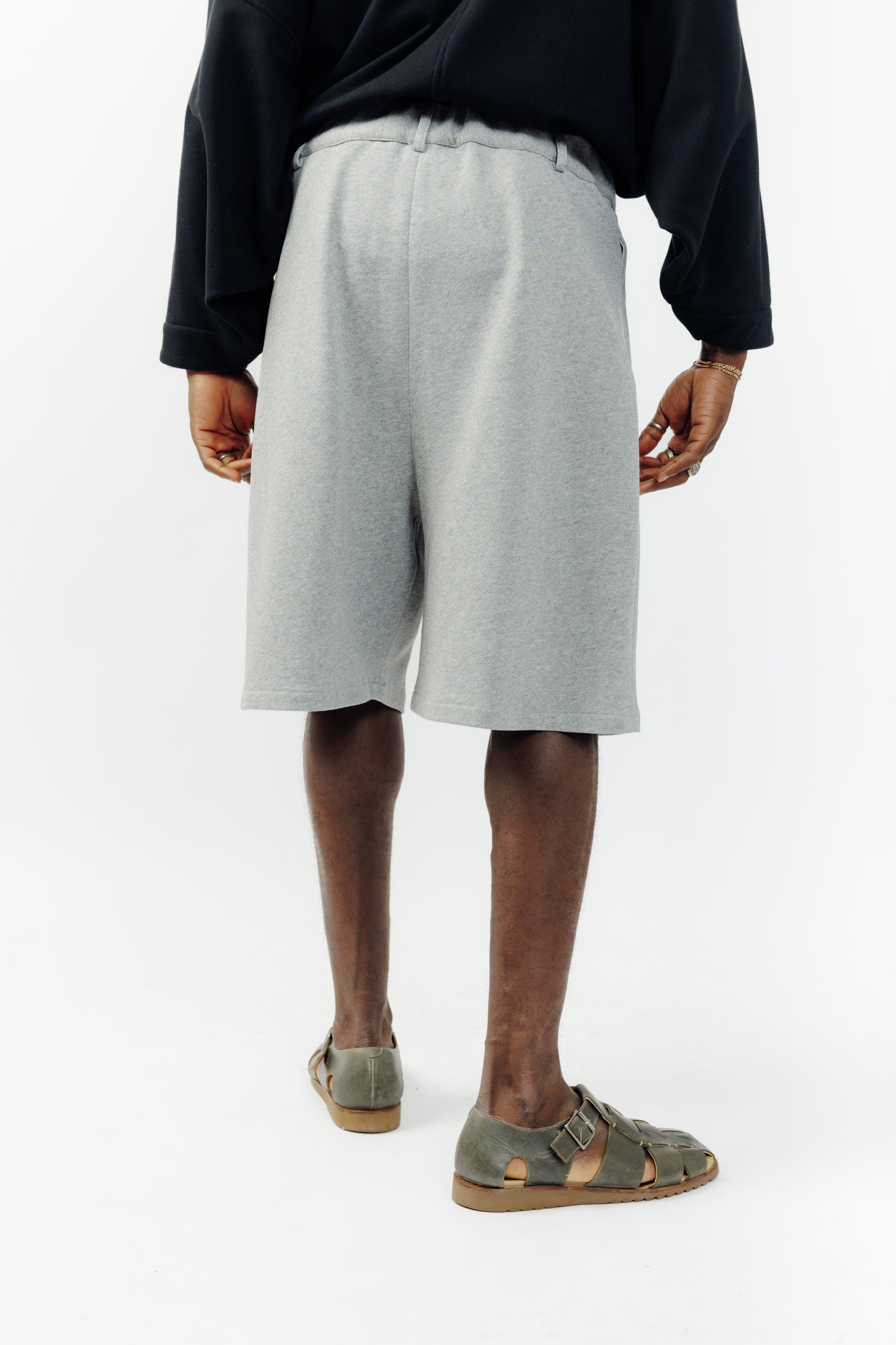 Short ballon de la marque Aïdama en molleton de coton gris chiné avec ceinture ajustable. Porté par un mannequin homme et vu de dos.