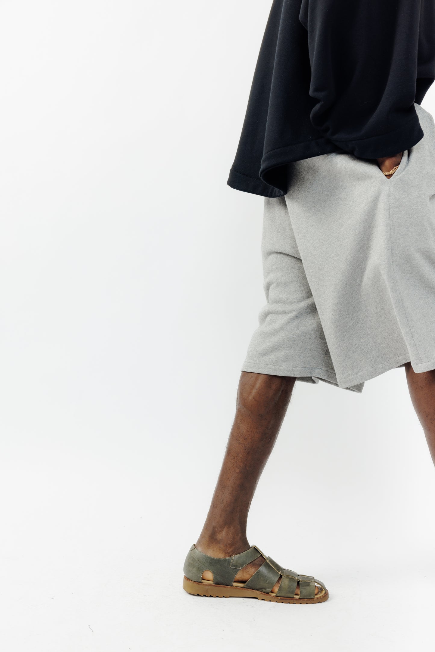 Short ballon de la marque Aïdama en molleton de coton gris chiné avec ceinture ajustable. Porté par un mannequin homme et vu de profil.