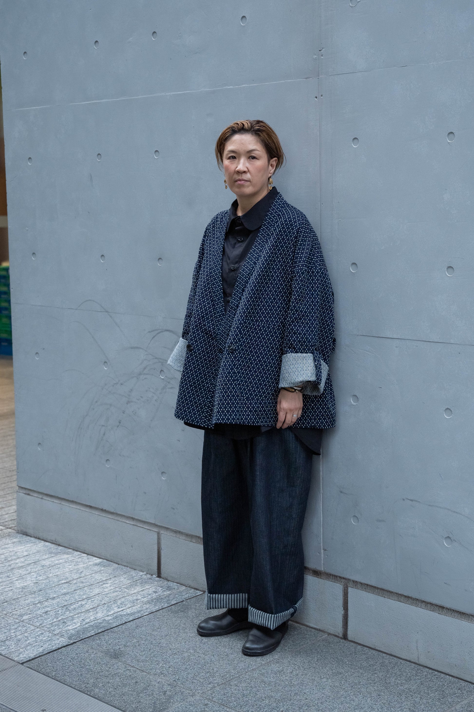Veste croisée à col kimono de la marque Aïdama, modèle Samue en coton japonais bleu brodé de points Sashiko. Portée ouverte par une mannequin femme et vue de face.
