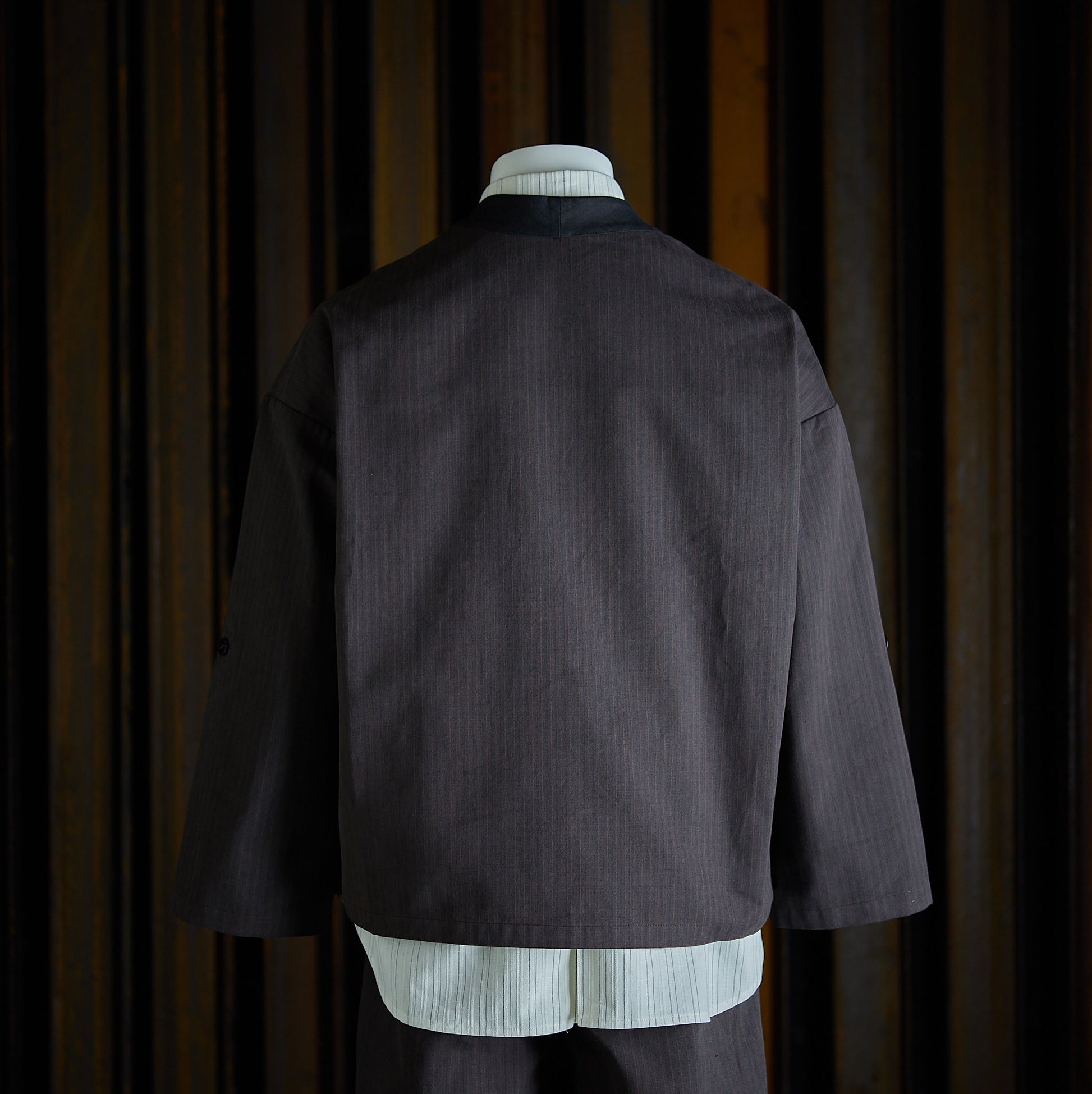Veste croisée à col kimono de la marque Aïdama, modèle samue en toile de coton brun à rayures tennis. Vue de dos sur mannequin.