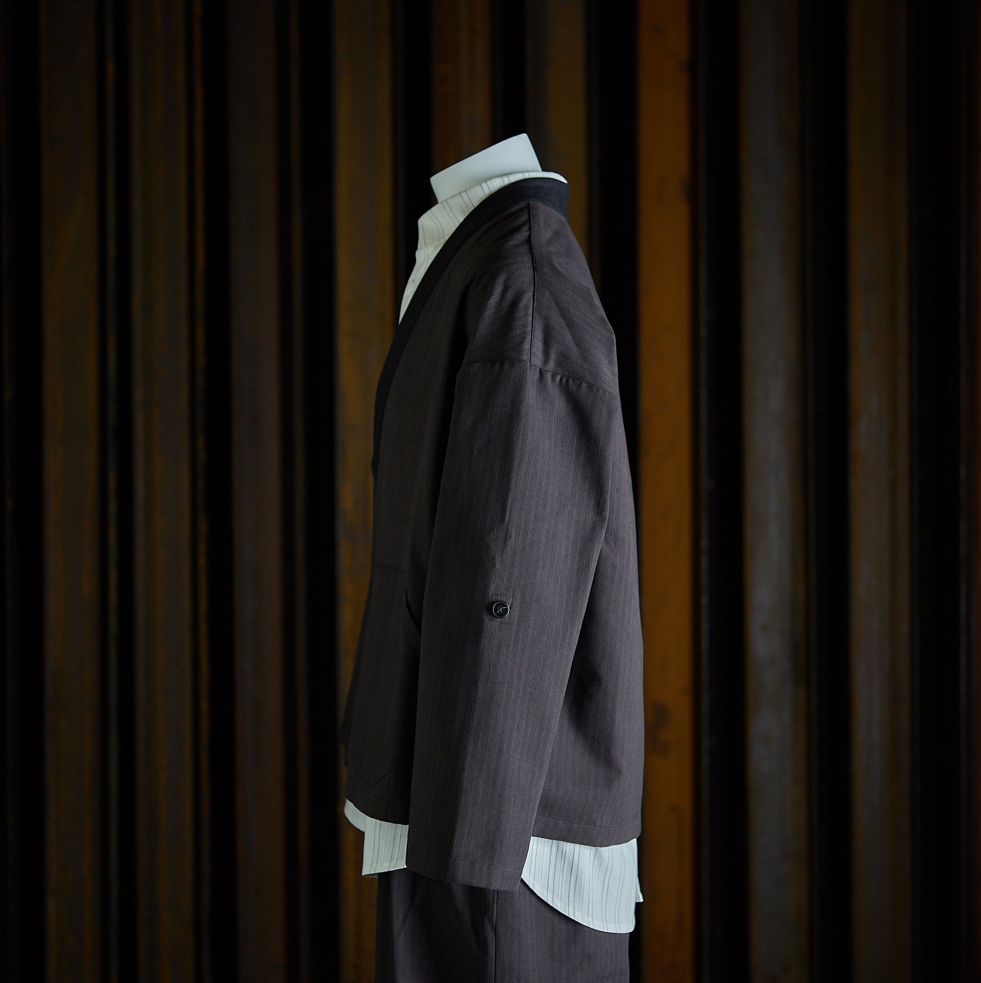 Veste croisée à col kimono de la marque Aïdama, modèle samue en toile de coton brun à rayures tennis. Vue de profil sur mannequin.